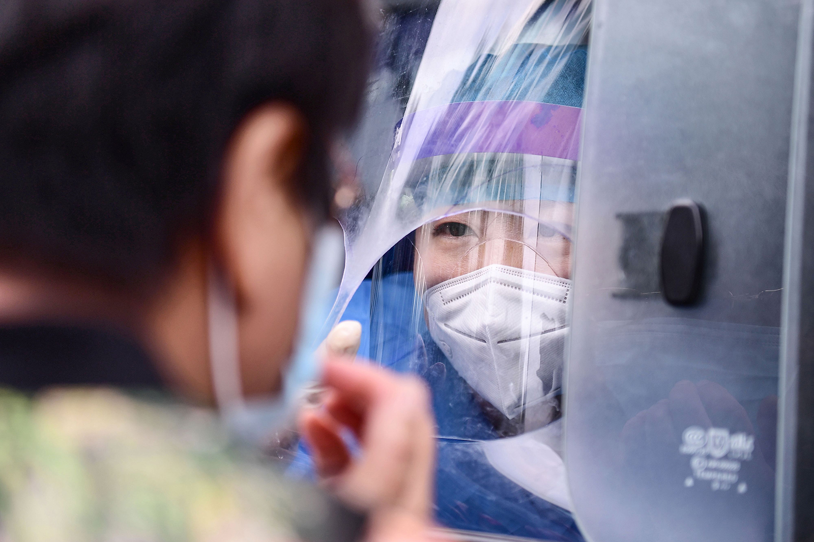 A health worker carries out a Covid-19 test on a resident in a testing vehicle in Shenyang in China's northeastern Liaoning province on July 29.