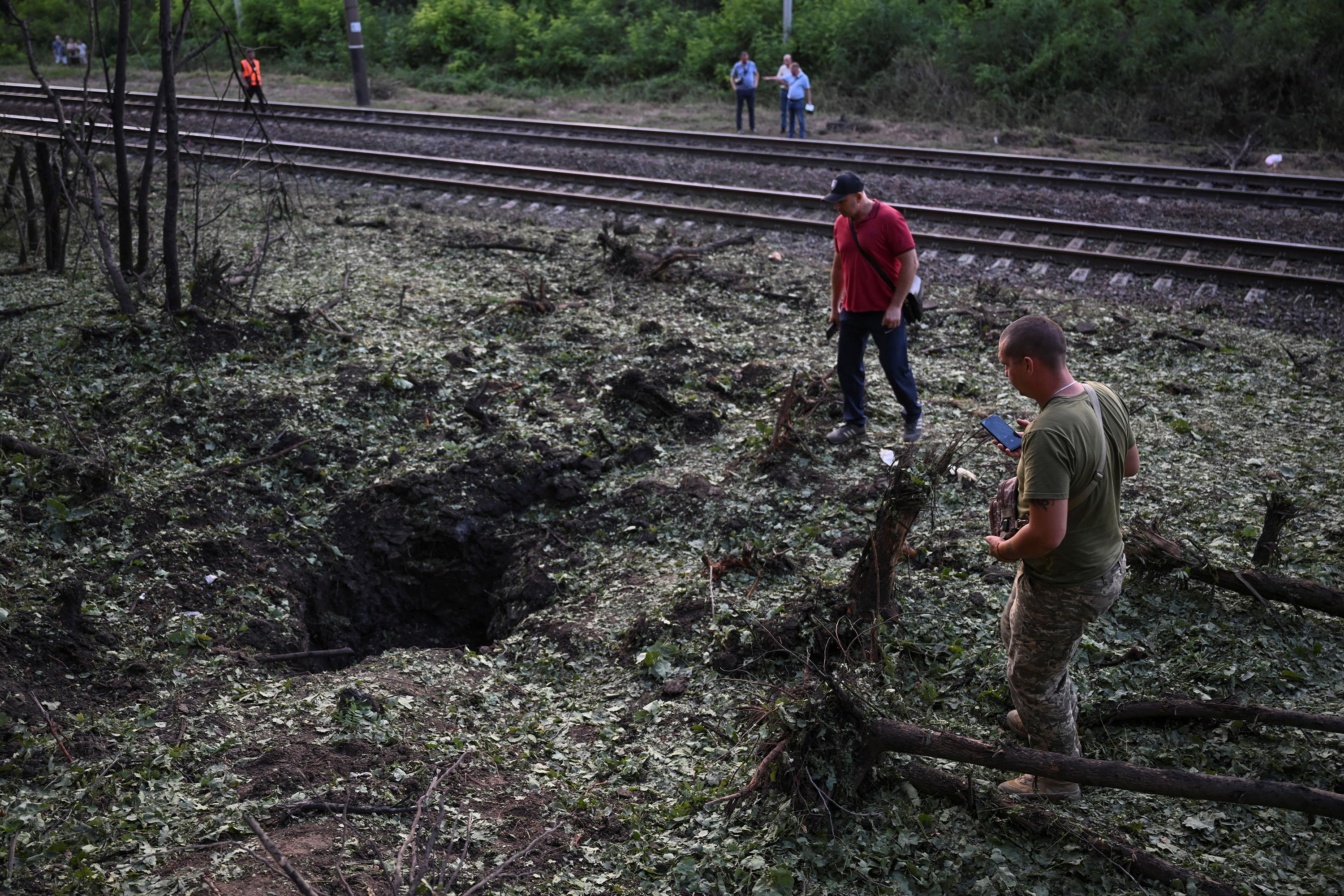 Local residents inspect a crater left after a Russian missile strike in Zaporizhzhia, Ukraine on July 29.