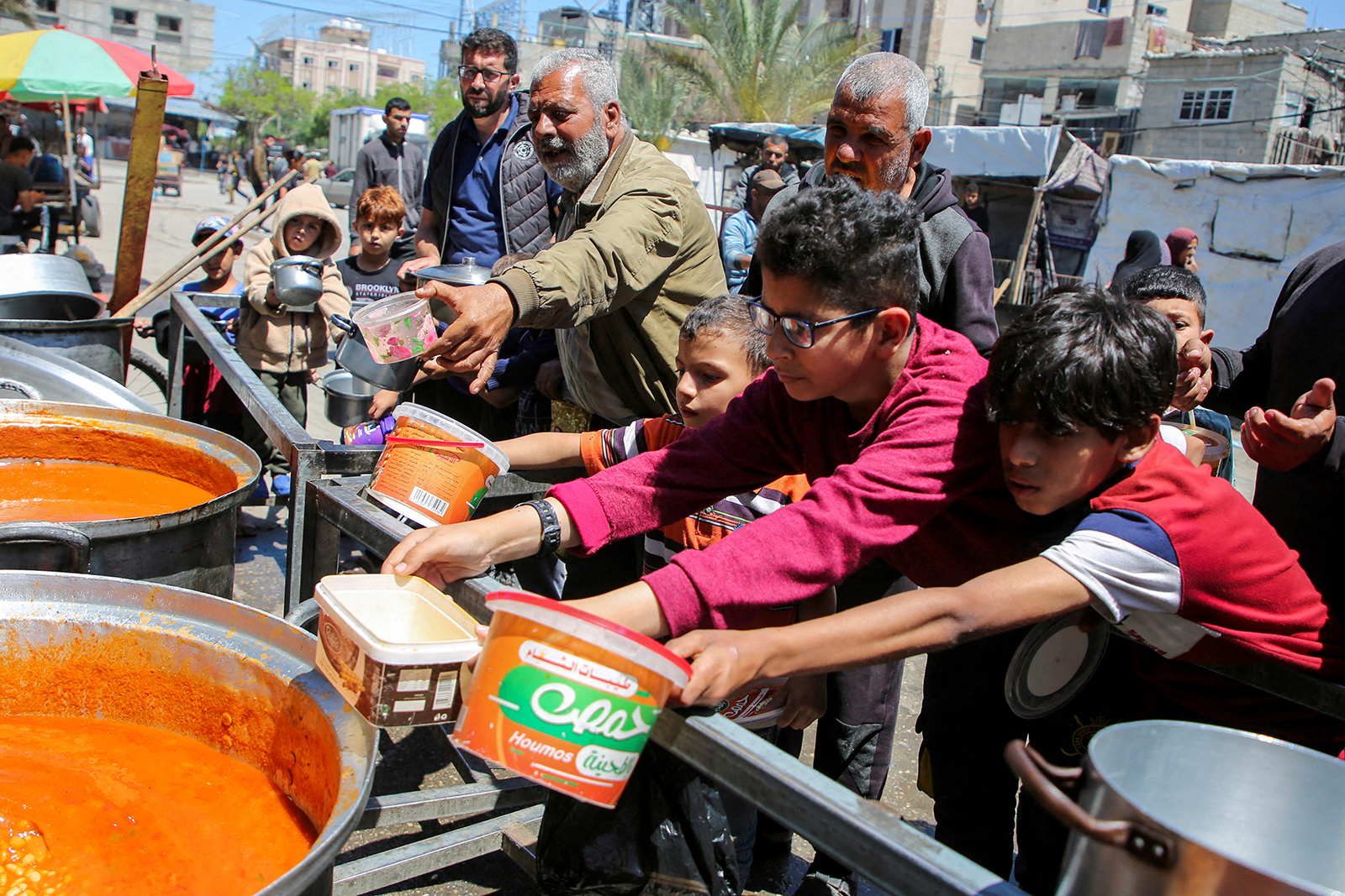 Palestinians gather to receive food cooked by a charity kitchen in Rafah, in southern Gaza, on May 8.