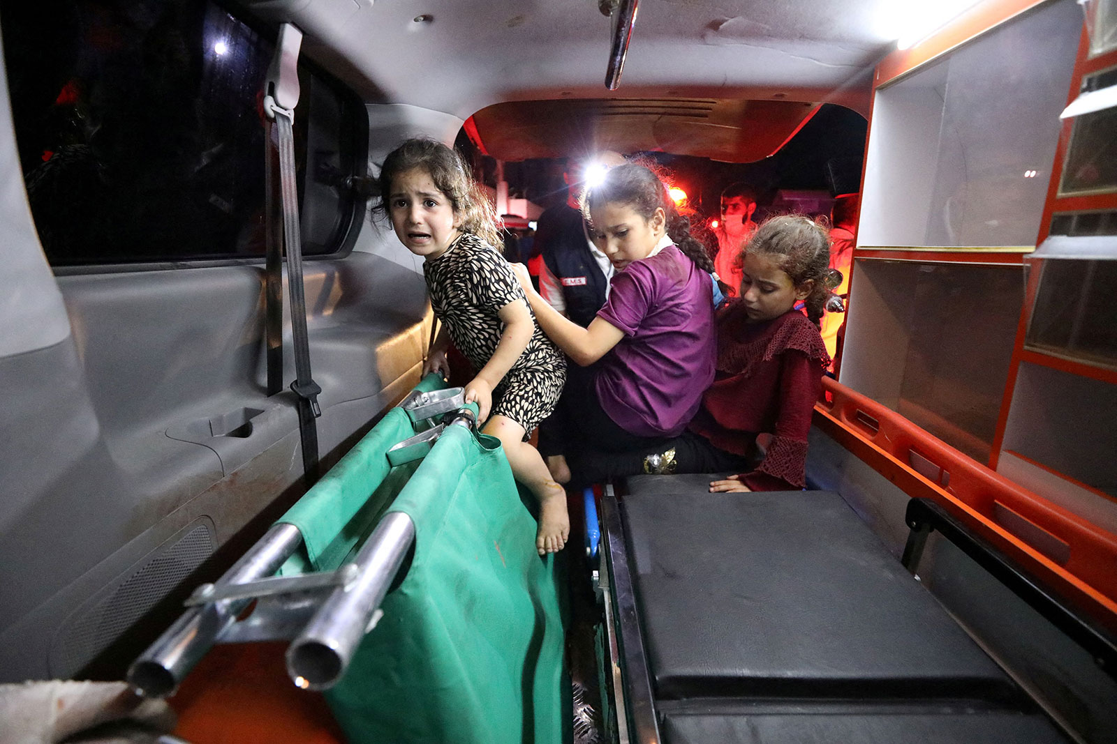 Children sit in the back of an ambulance at Al-Shifa Hospital in Gaza City following a blast at Al-Alhi Baptist Hospital on October 17.