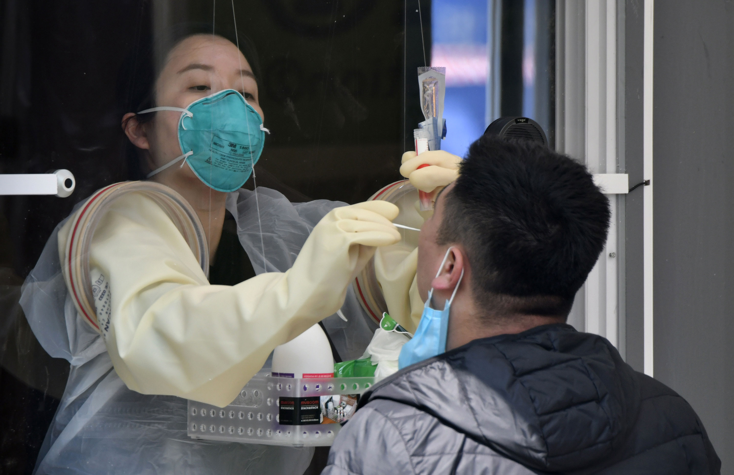 A medic administers a coronavirus test at a walk-thru testing station at Jamsil Sports Complex, in Seoul, on April 3.