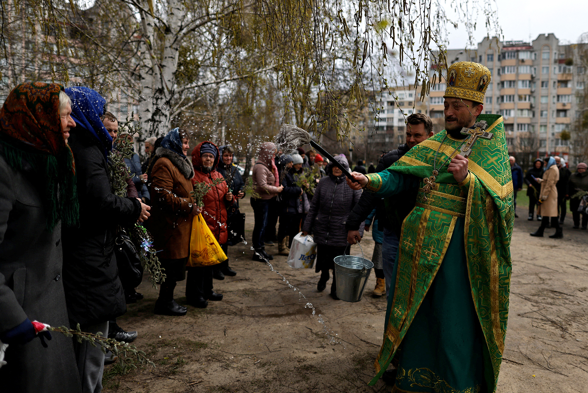 An Orthodox priest sprays holy water on worshippers after a Palm Sunday service in Bucha, Ukraine. 