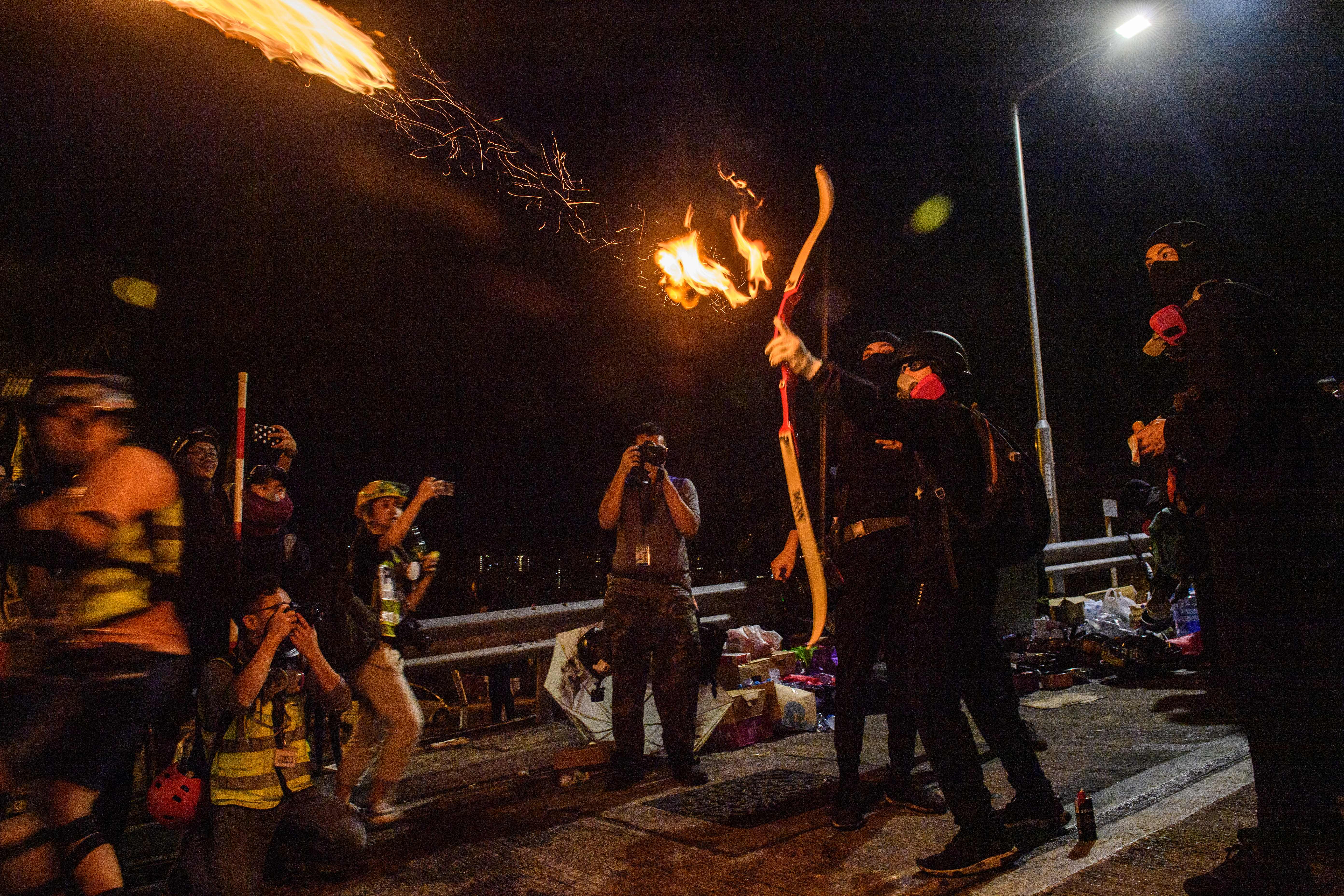 A protester releases a flaming arrow at the Chinese University of Hong Kong early on November 13, 2019.