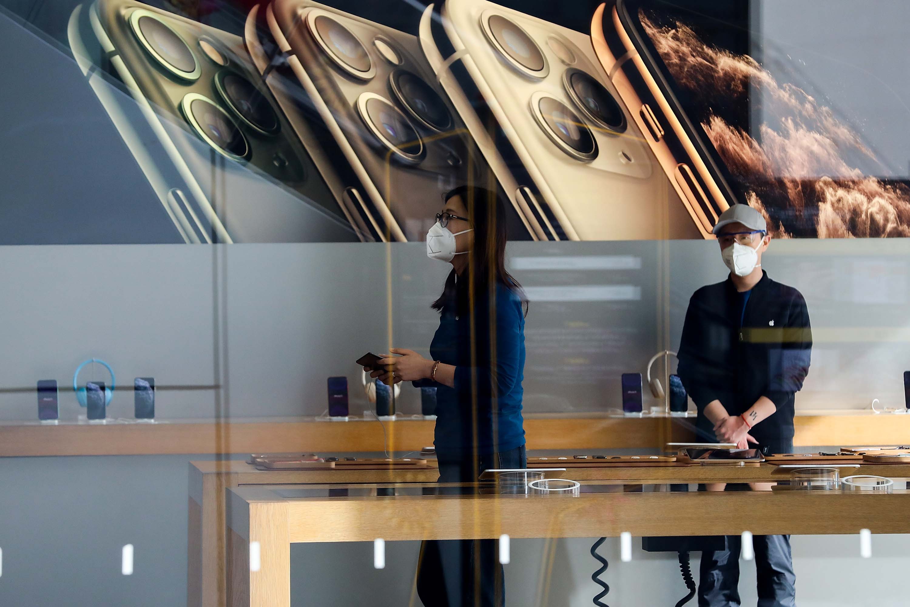 Employees wear face masks at an Apple Store in Beijing on Monday.