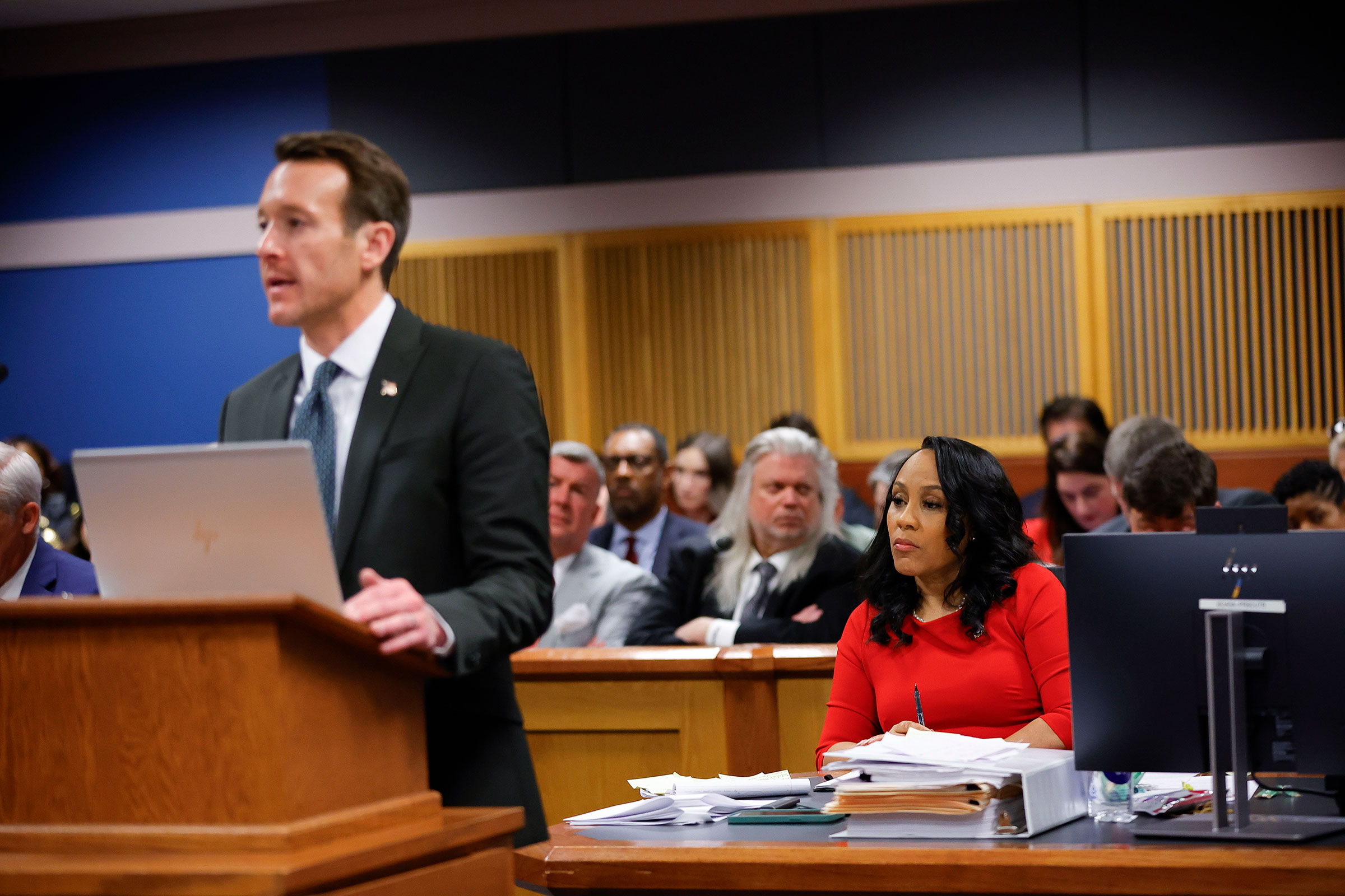 Attorney Adam Abbate speaks with Fulton County District Attorney Fani Willis looking on during a hearing on the Georgia election interference case, Friday, March, 1, in Atlanta.