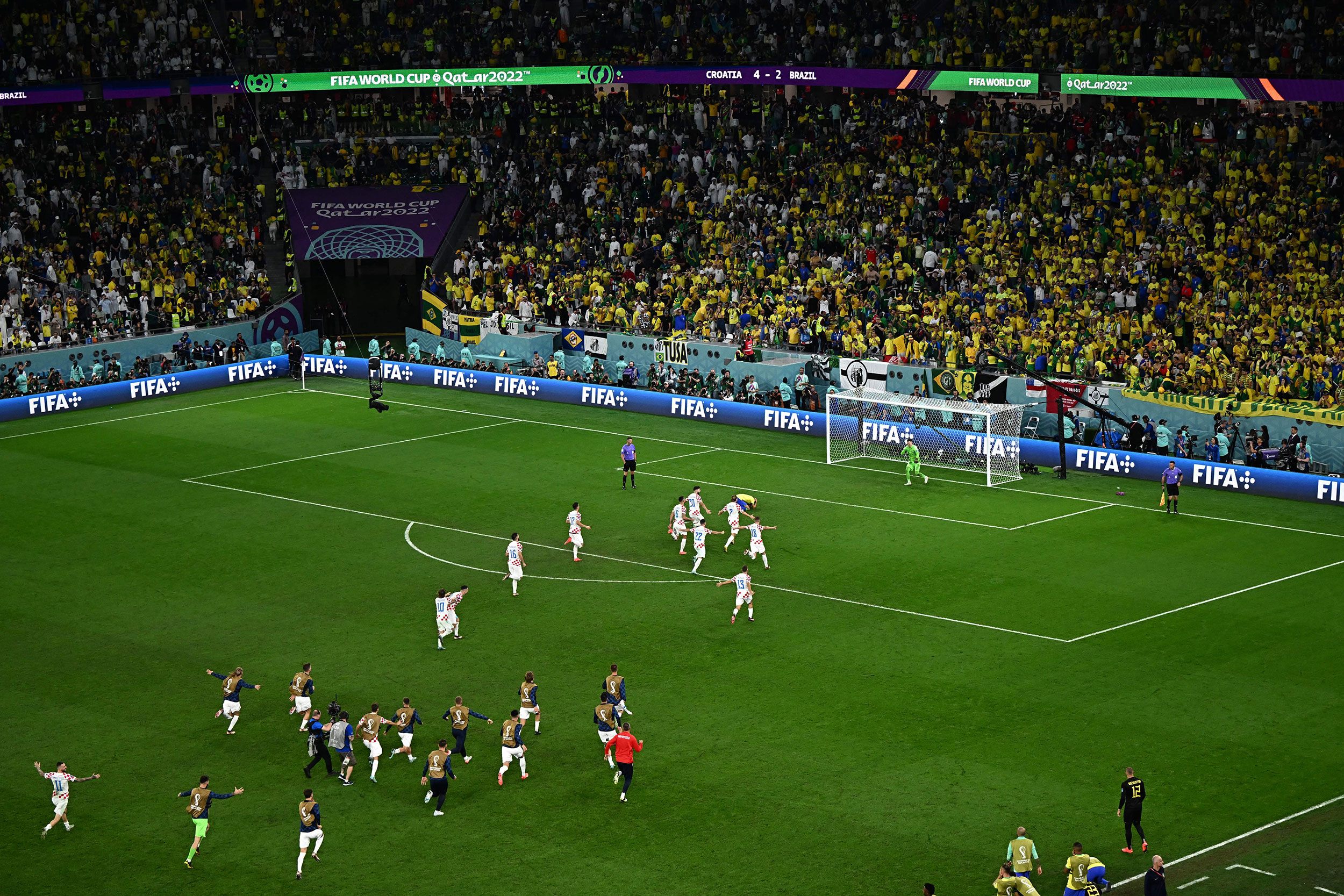 Croatia players rush towards the net after winning the match.