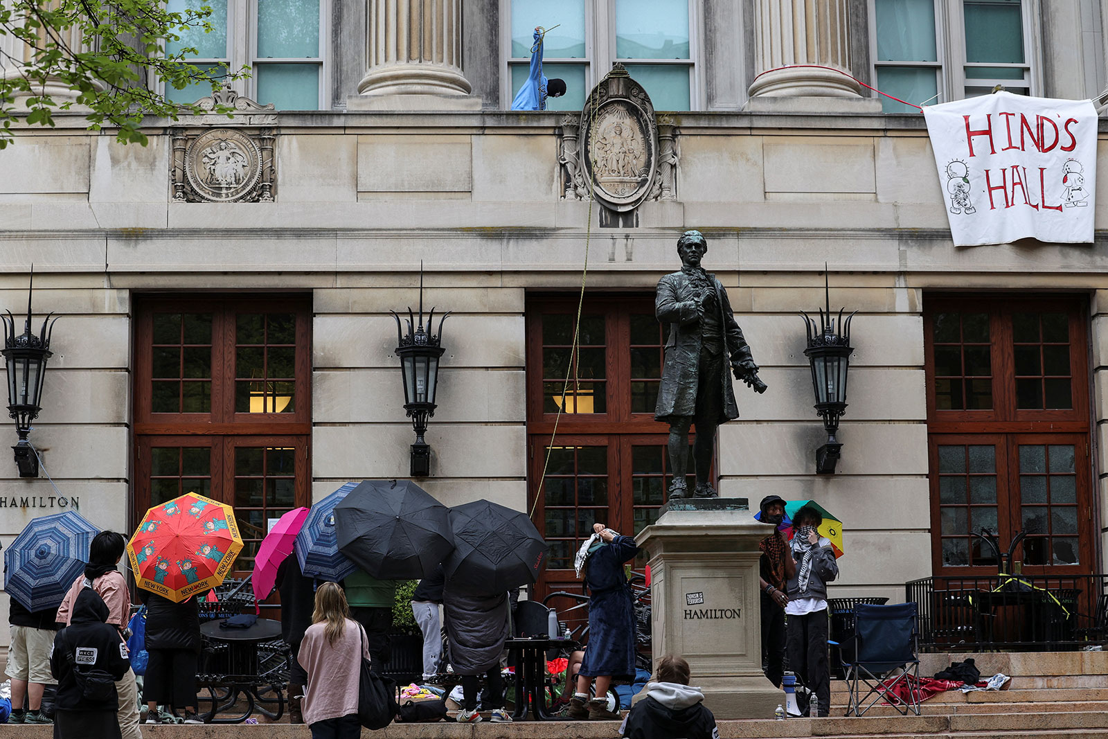 Protesters hold umbrellas as they move supplies into Hamilton Hall in New York on Tuesday.