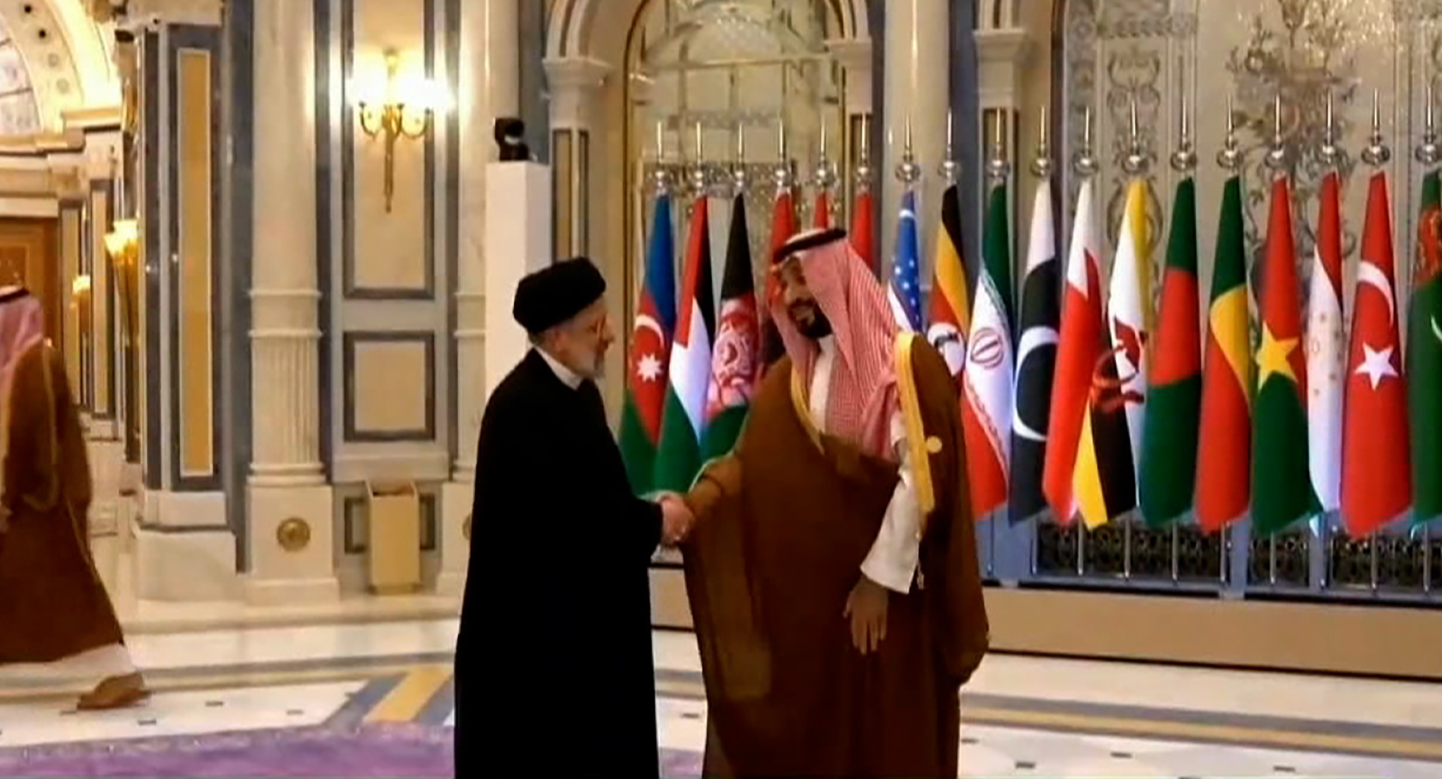 Iranian President Ebrahim Raisi, left, shakes hands with Saudi Crown Prince Mohammed bin Salman on November 11. 
