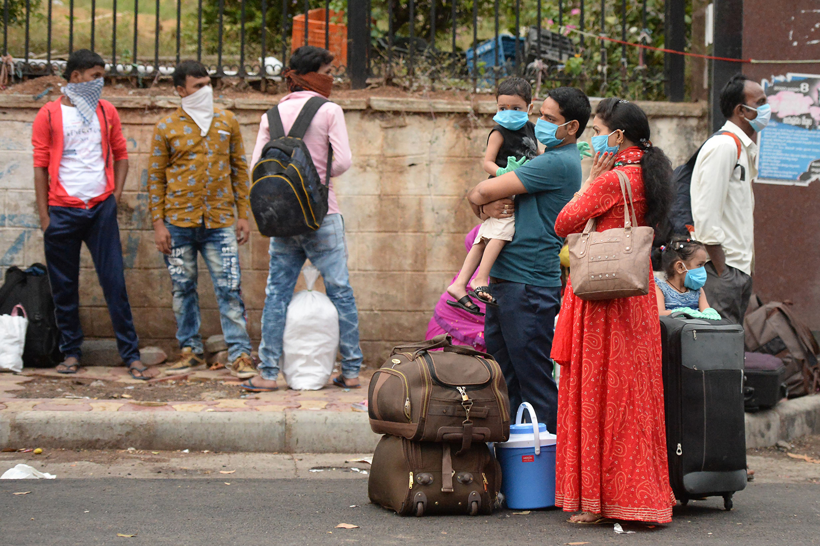 Passengers wearing face masks wait outside a railway station before boarding a train in Secunderabad on June 1.