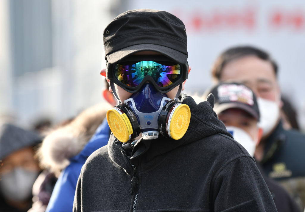 A man wears a mask and goggles as he waits in line to buy face masks from a post office in Daegu on February 27.