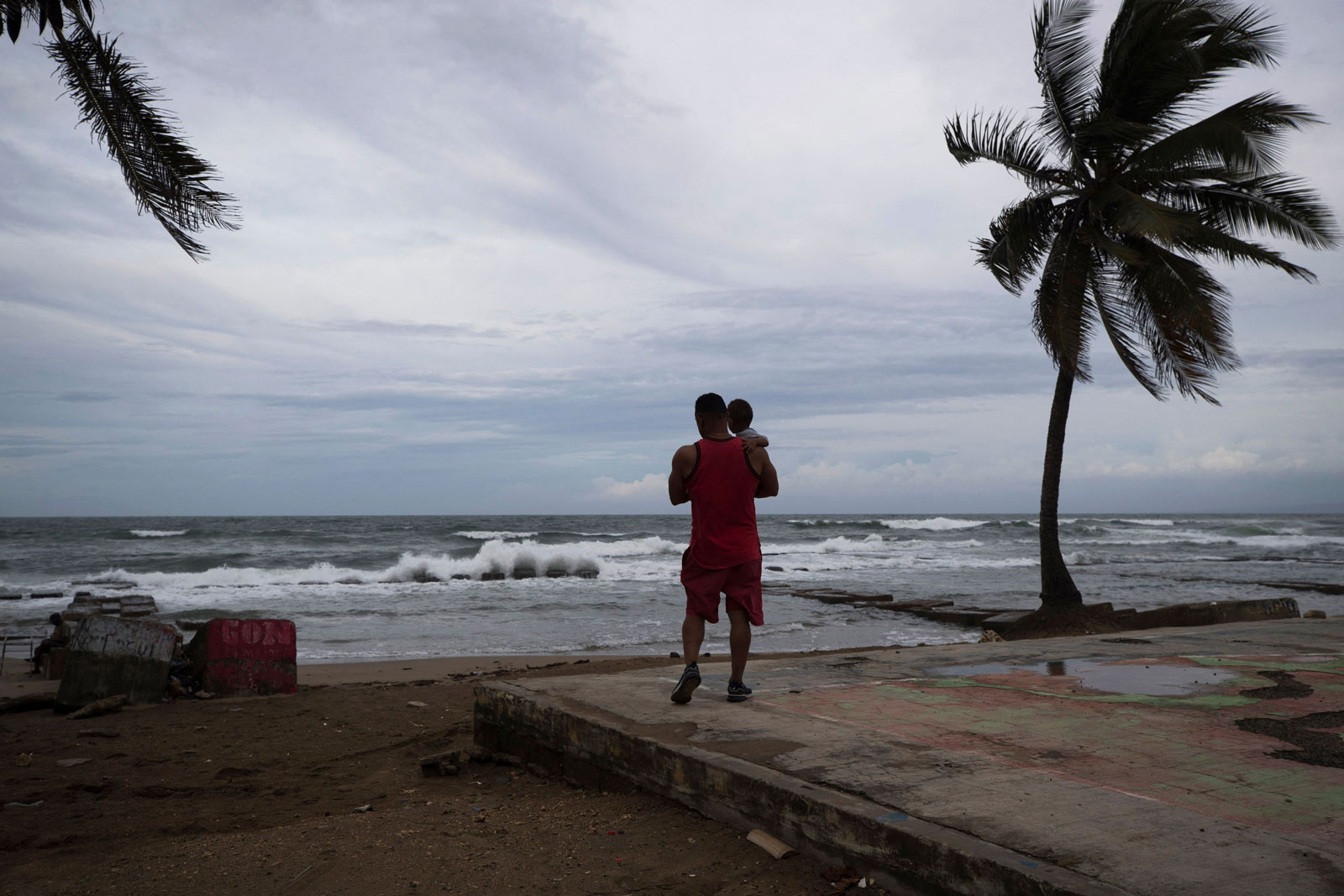 A man with his son is seen on the beach in Nagua, Dominican Republic, on Sunday.