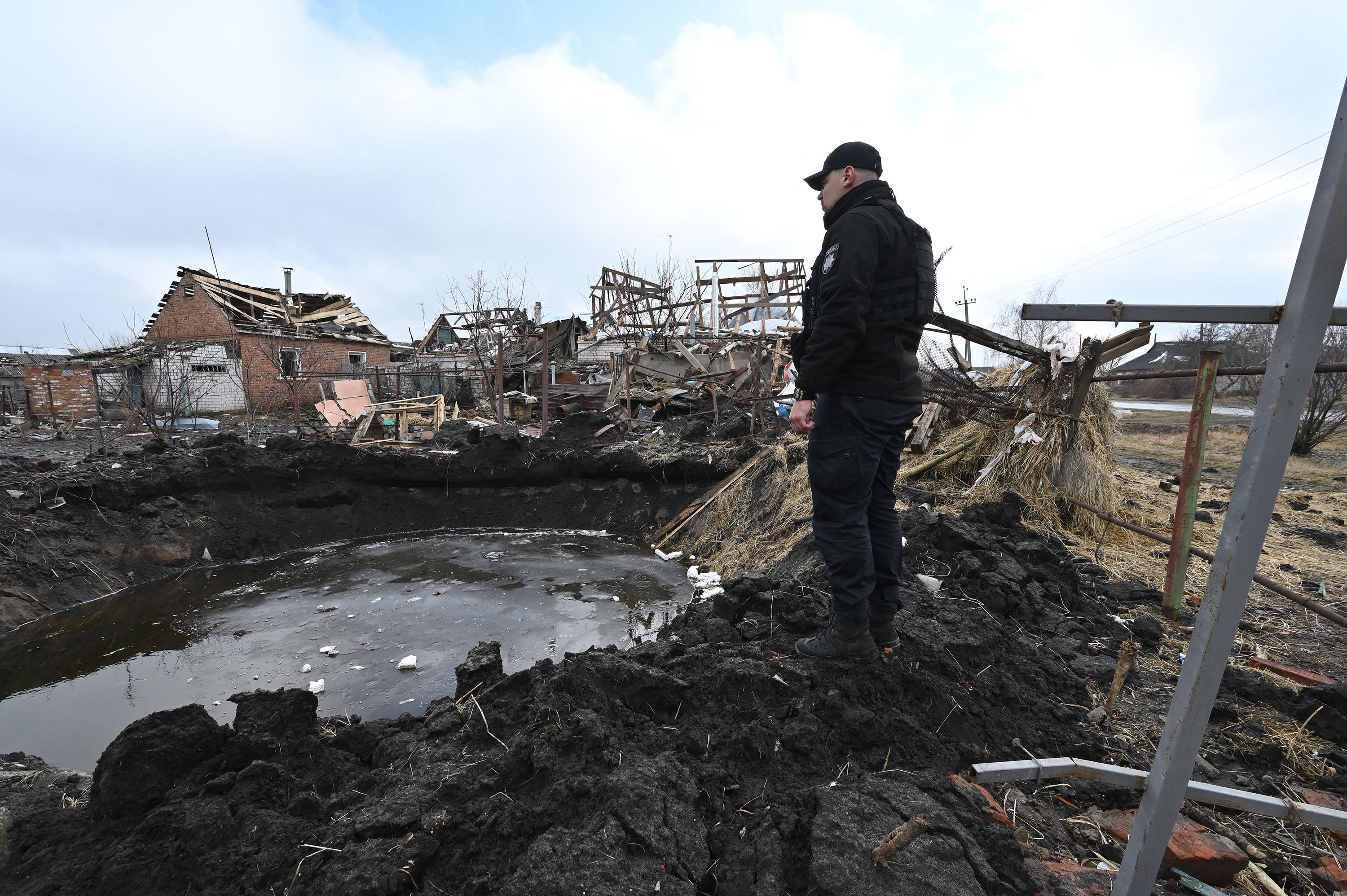 A policeman examines a crater after Russian shelling in Vovchansk, Ukraine, on March 9. 
