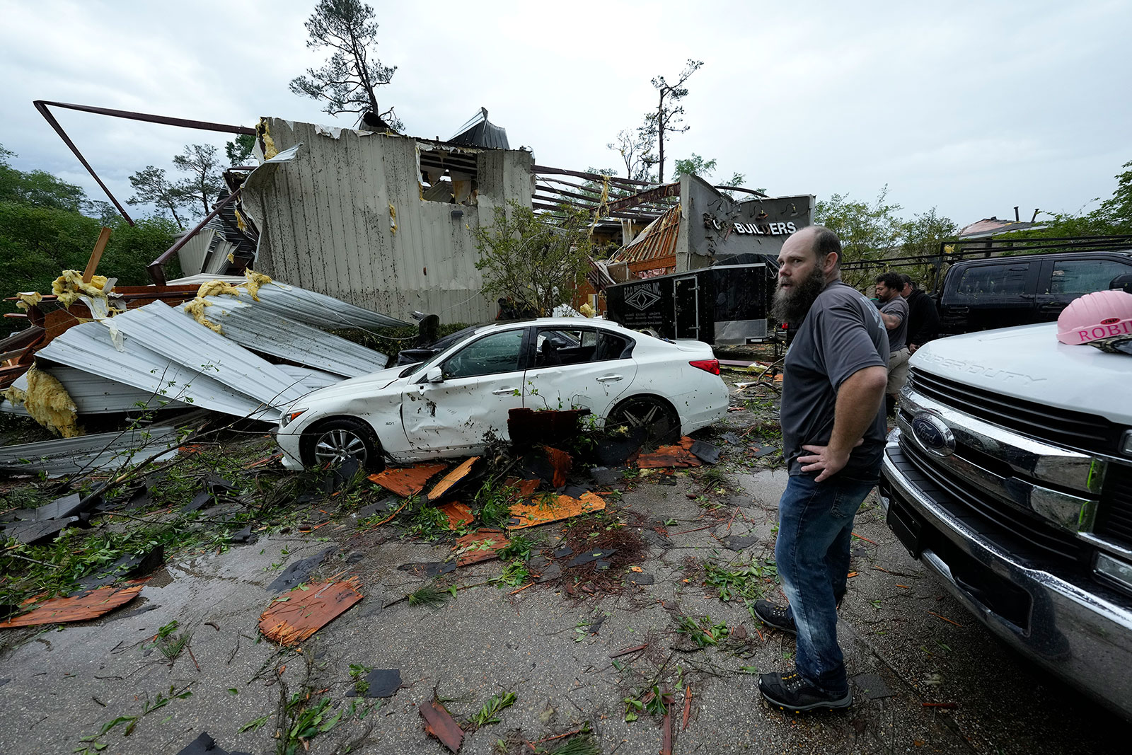 People stand outside a heavily damaged building in Slidell, Louisiana, on Wednesday.