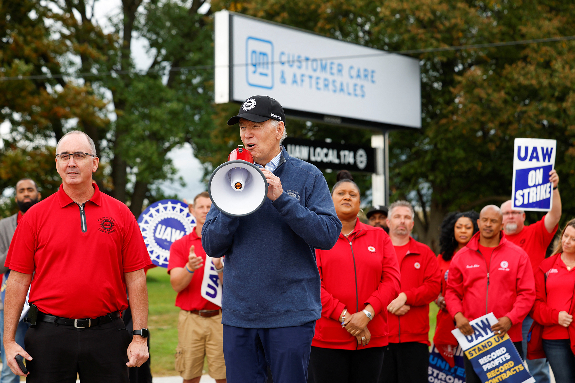 U.S. President Joe Biden speaks next to Shawn Fain, President of the United Auto Workers (UAW), as he joins striking members of the United Auto Workers (UAW) on the picket line outside the GM's Willow Run Distribution Center, in Bellville, Wayne County, Michigan today.