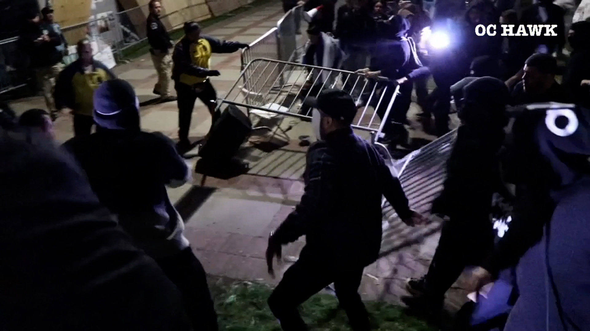 Counter protesters pull metal barricades around the pro-Palestinian encampment on the University of California, Los Angeles campus overnight. 