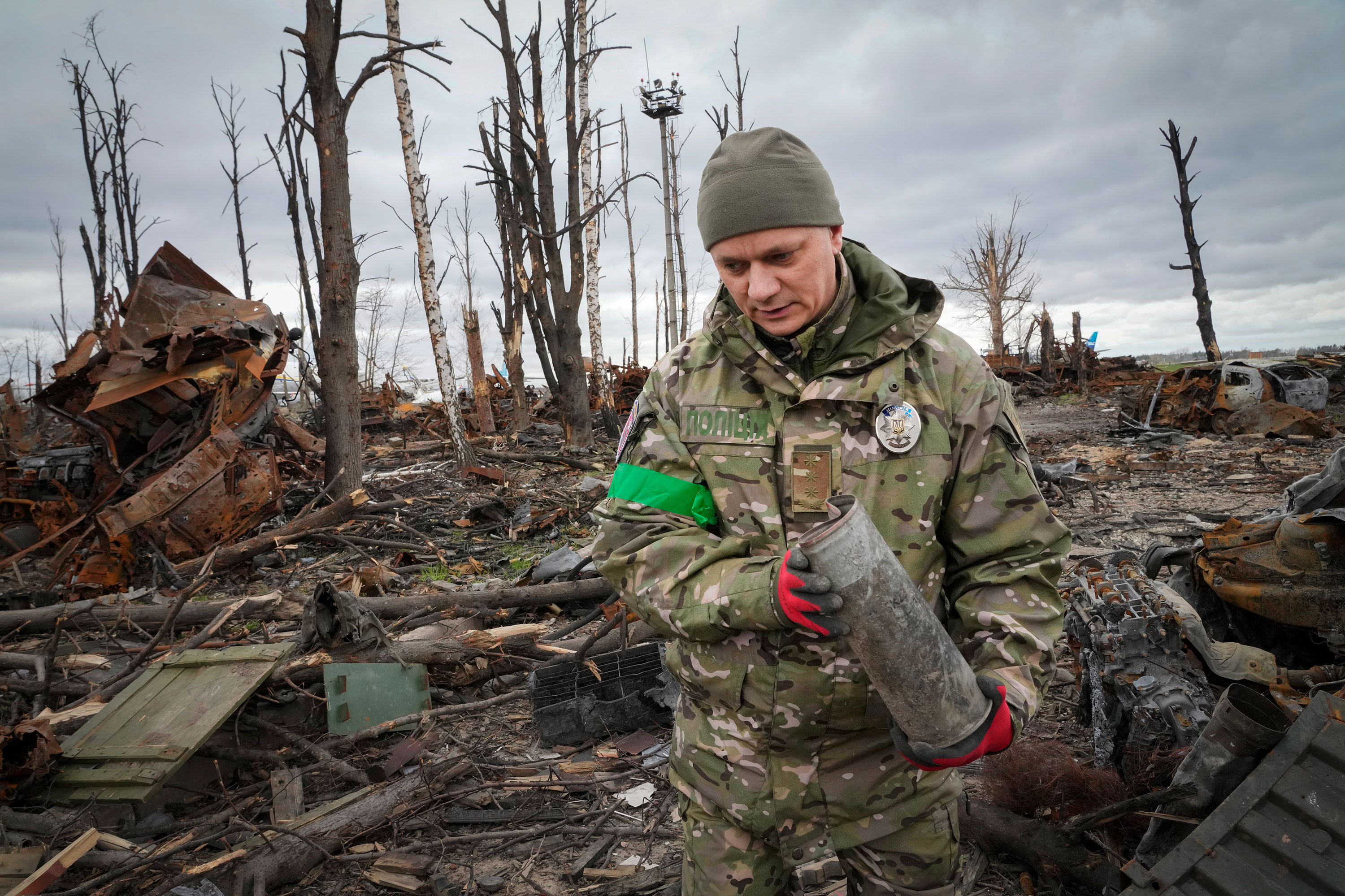 İçişleri Bakanlığı'nın kazıcı, 18 Nisan'da Ukrayna'nın Hostomel şehrinde patlamamış mühimmat topluyor.