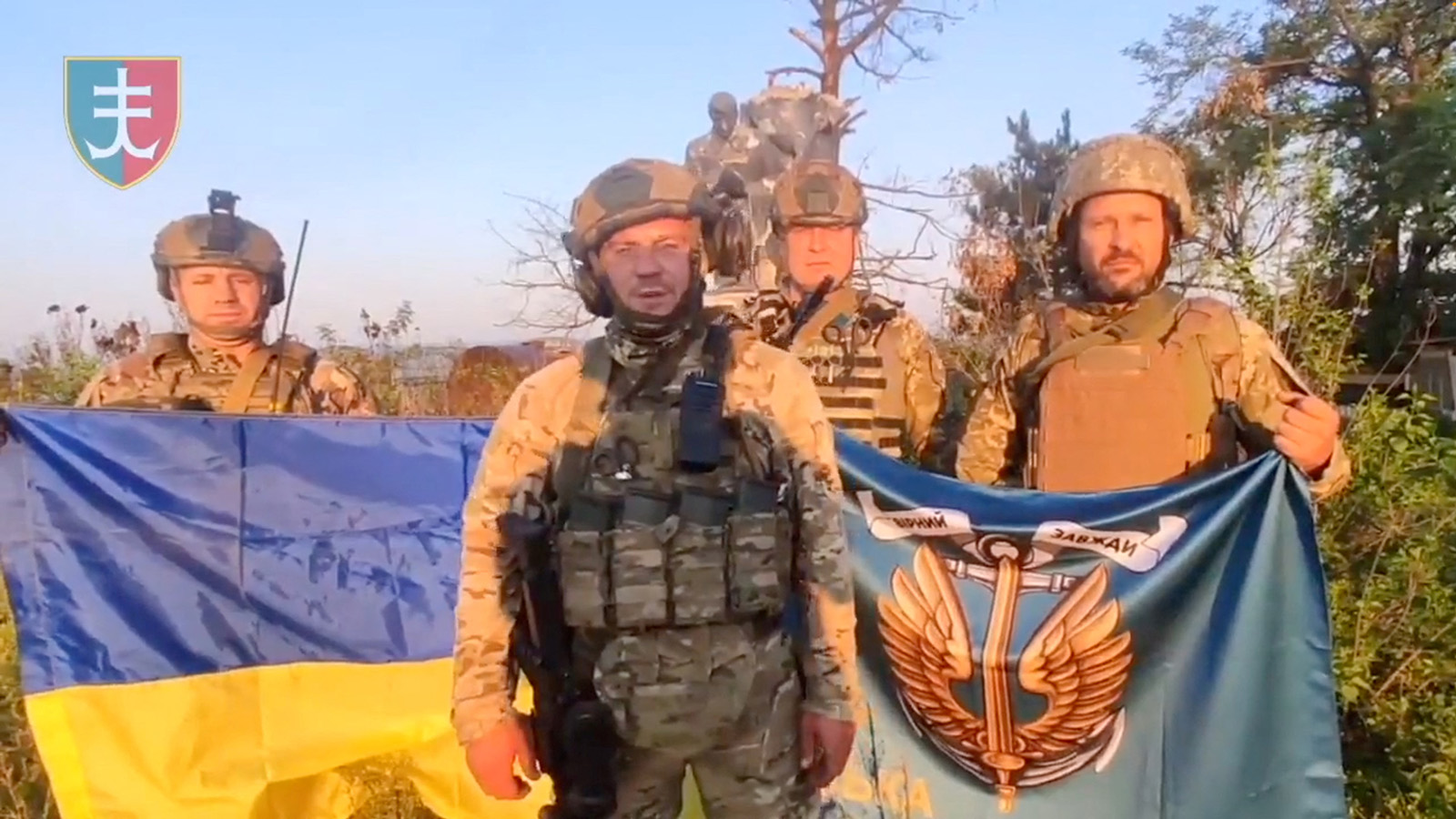 Ukrainian soldiers stand with Ukrainian flag in Urozhaine, Donetsk Region, Ukraine, in this screen grab obtained from a handout video released on August 16.