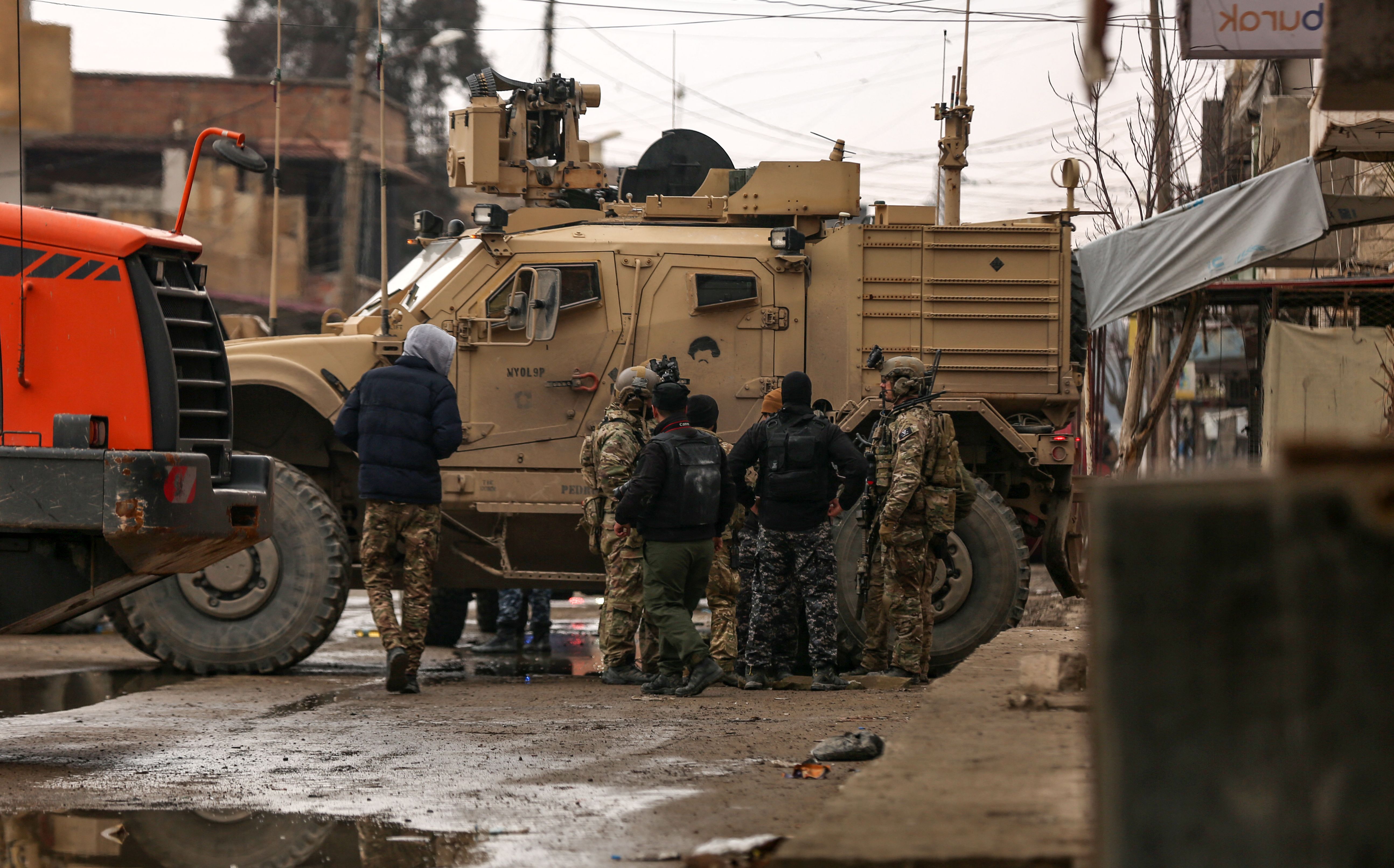 US soldiers accompanied by members of the Syrian Democratic Forces (SDF) gather in the neighbourhood of Ghwayran in the northeastern Syrian city of Hasakeh, on January 29, as they search for prisoners believed to be affiliated with the Islamic State (IS) group, who had escaped from the Kurdish-held Sinaa prison (also known as Ghwayran prison) during an IS attack.