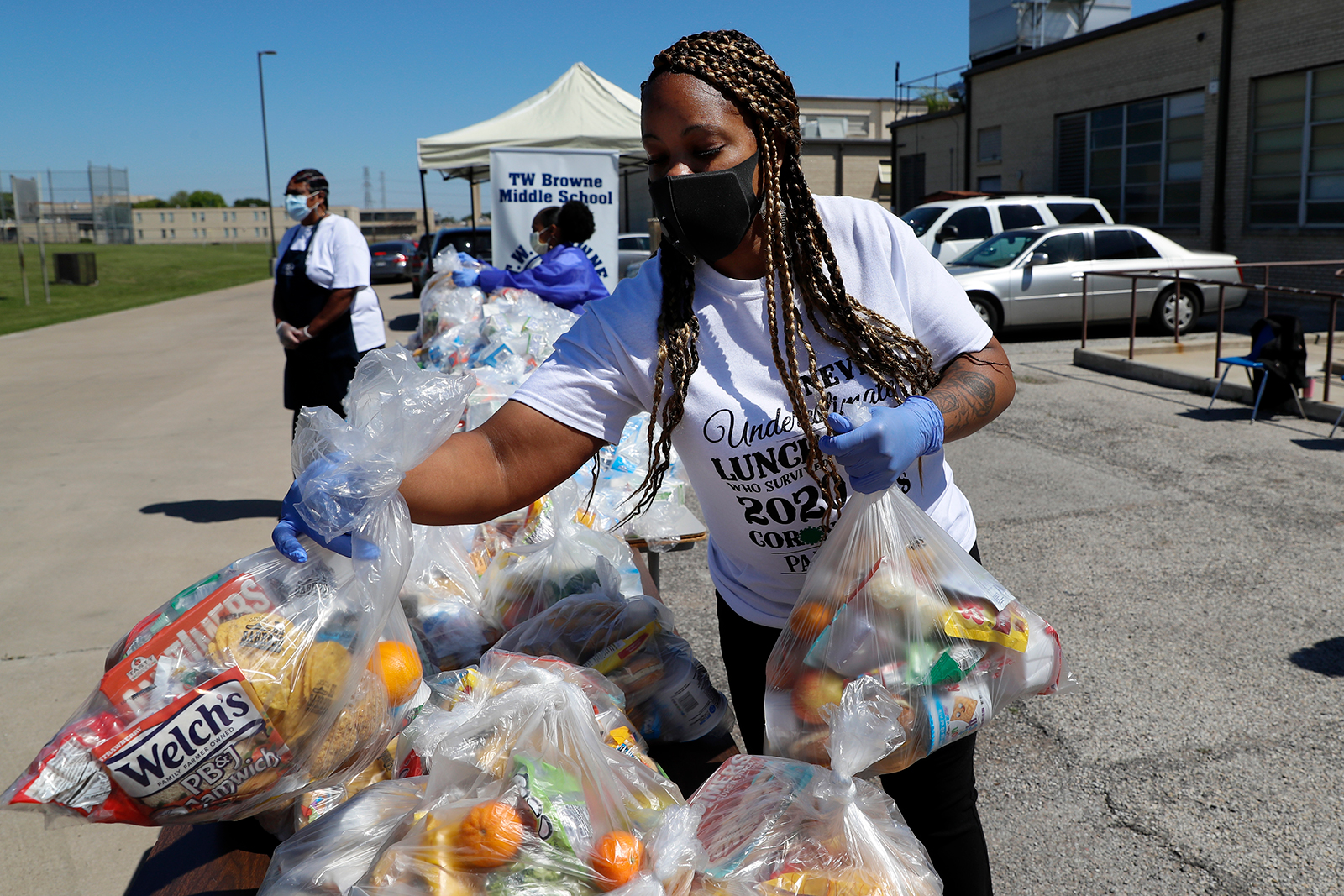 T.W. Browne Middle School food service employee Keke LaFayette, prepares to distribute food to a Dallas Independent School District family in Dallas, on April 16.