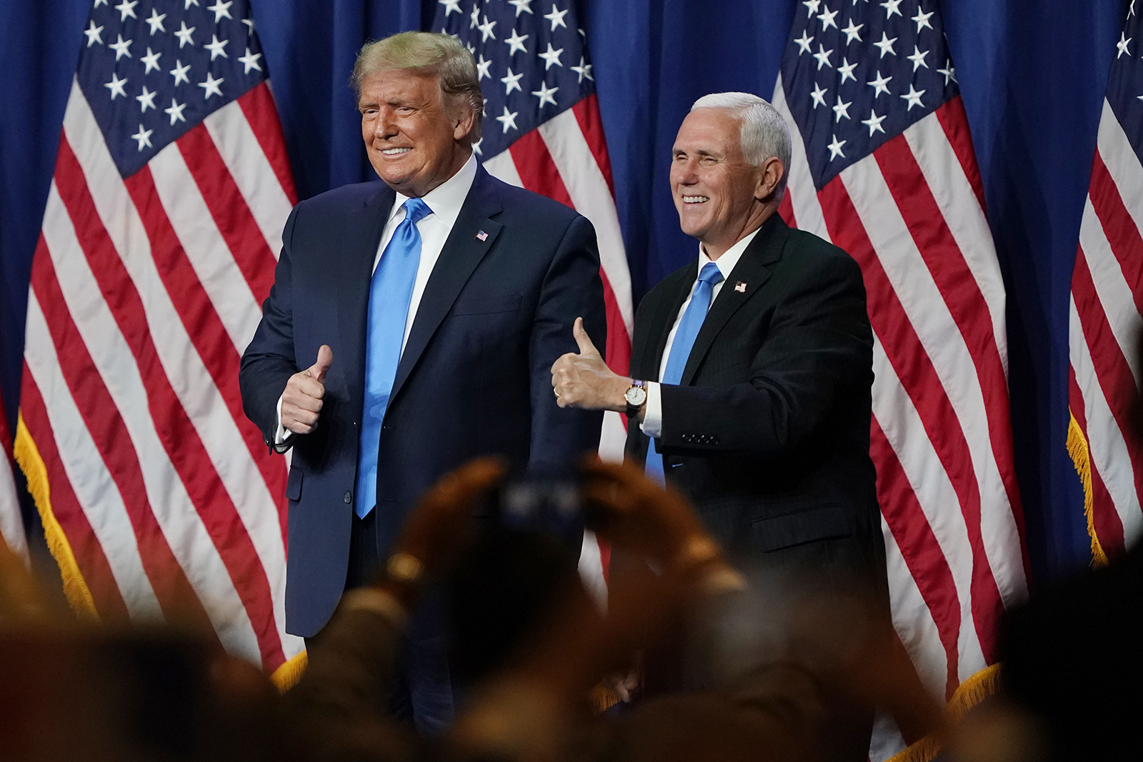 President Donald Trump and Vice President Mike Pence give a thumbs up after speaking during the first day of the Republican National Convention Monday, August 24 in Charlotte, North Carolina.