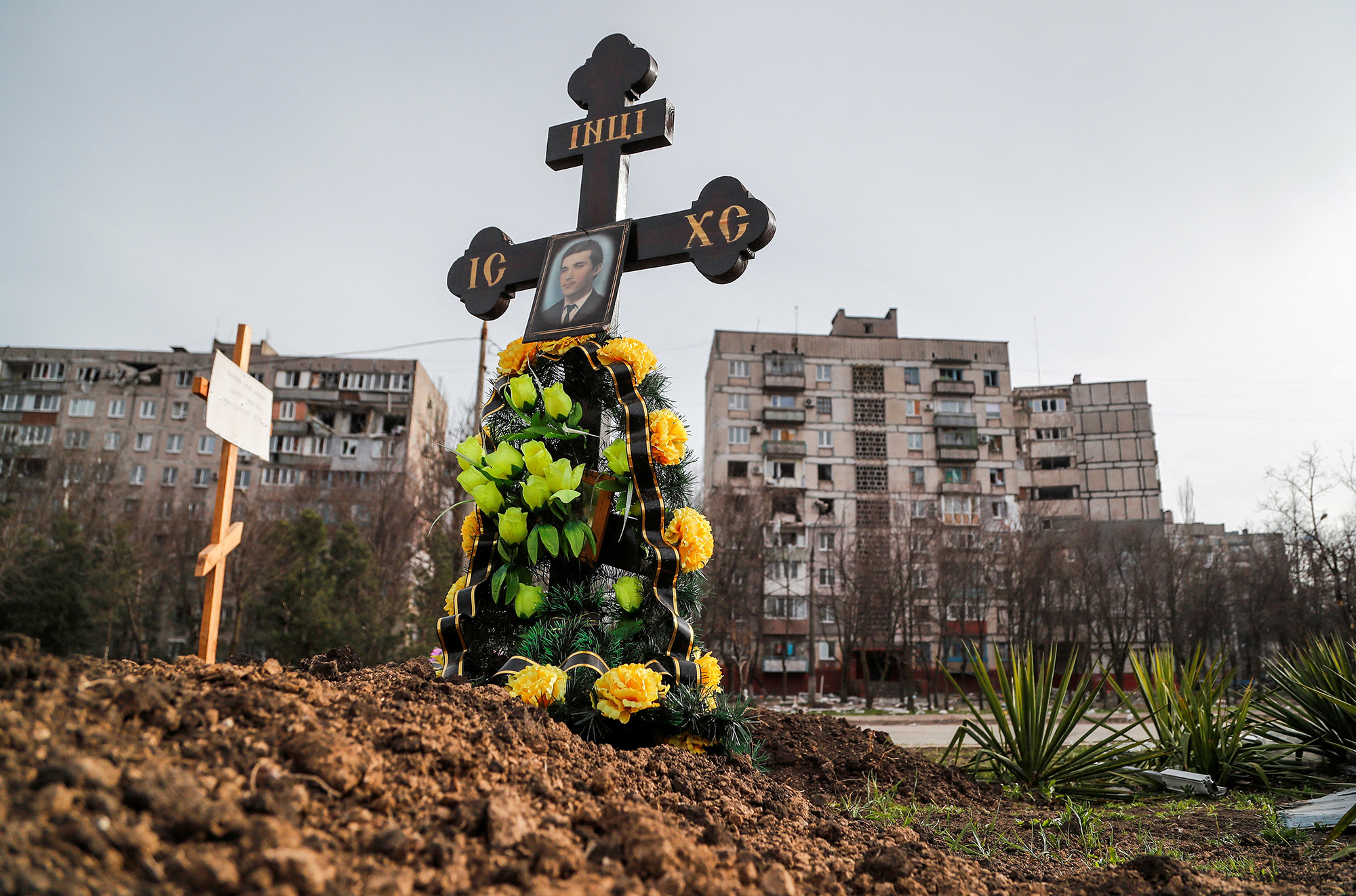 Graves of civilians killed during the Russian invasion are seen next to apartment buildings in the southern port city of Mariupol, Ukraine, on April 10.