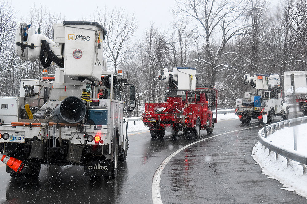 Utility repair crews caravan to a staging site during a winter snow storm on Tuesday, March 14, in Albany, New York.