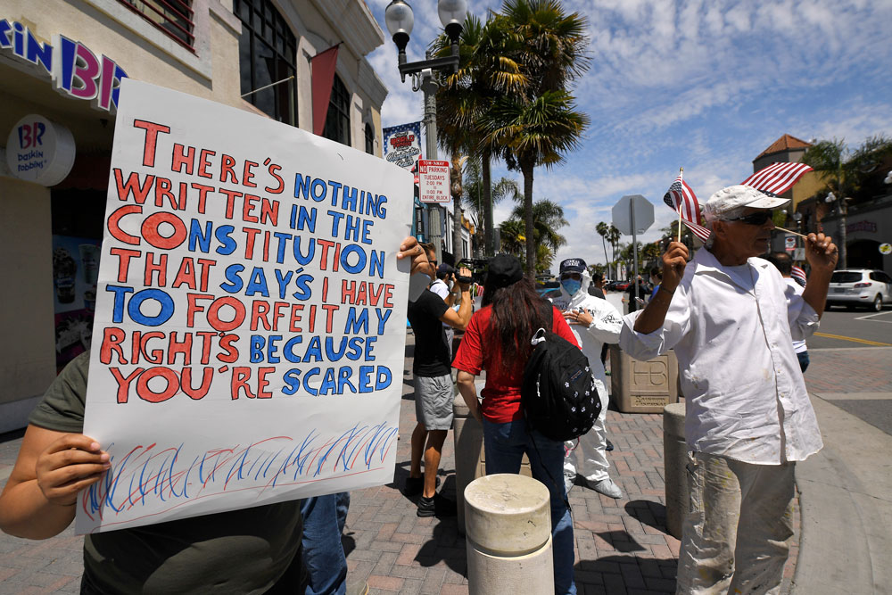 Protesters demonstrate against stay-at-home orders that were put in place due to the coronavirus outbreak on Friday, April 17 in Huntington Beach, California.