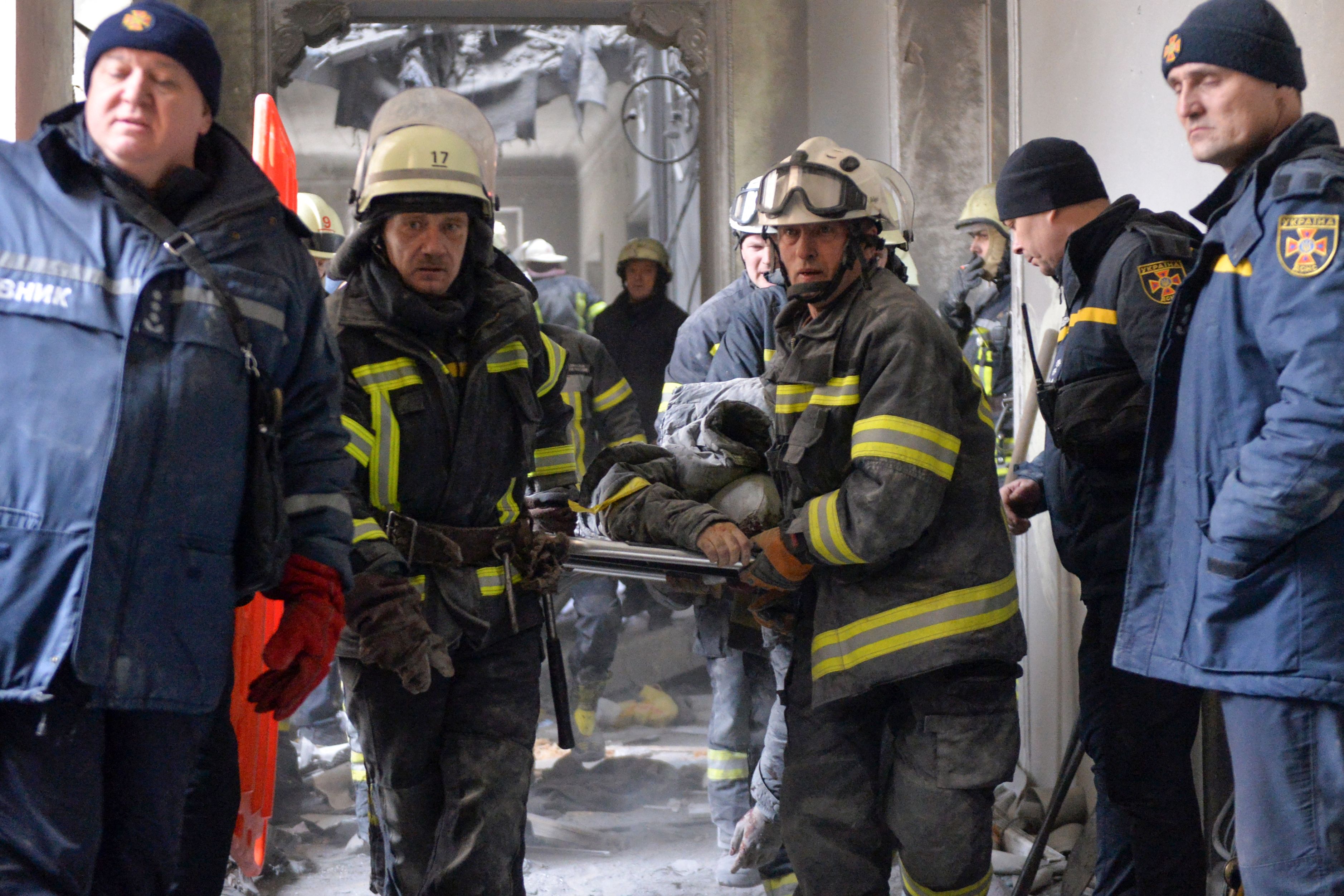 Emergency personnel carry a body out of the damaged local city hall of Kharkiv, Ukraine, on March 1.