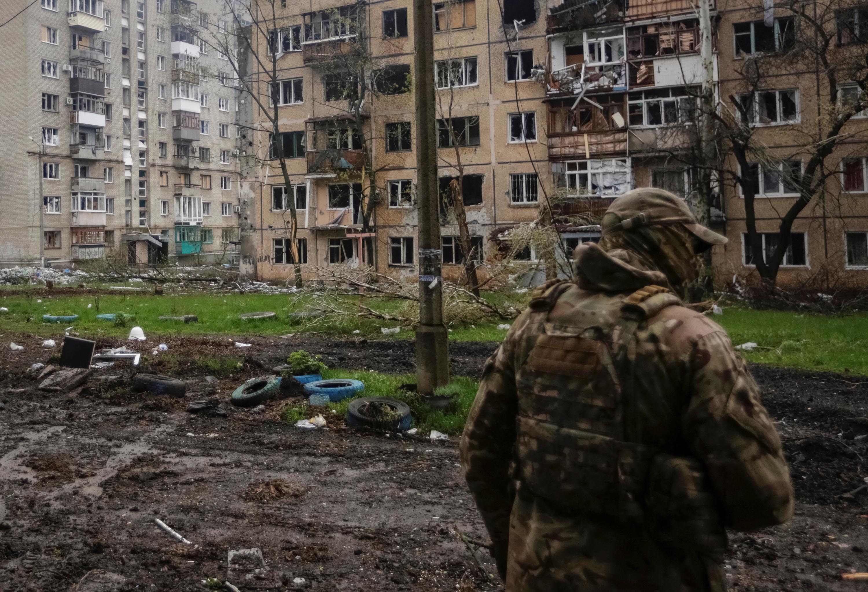 A Ukrainian service member walks near residential buildings damaged by a Russian military strike in Bakhmut, Ukraine, on April 21. 