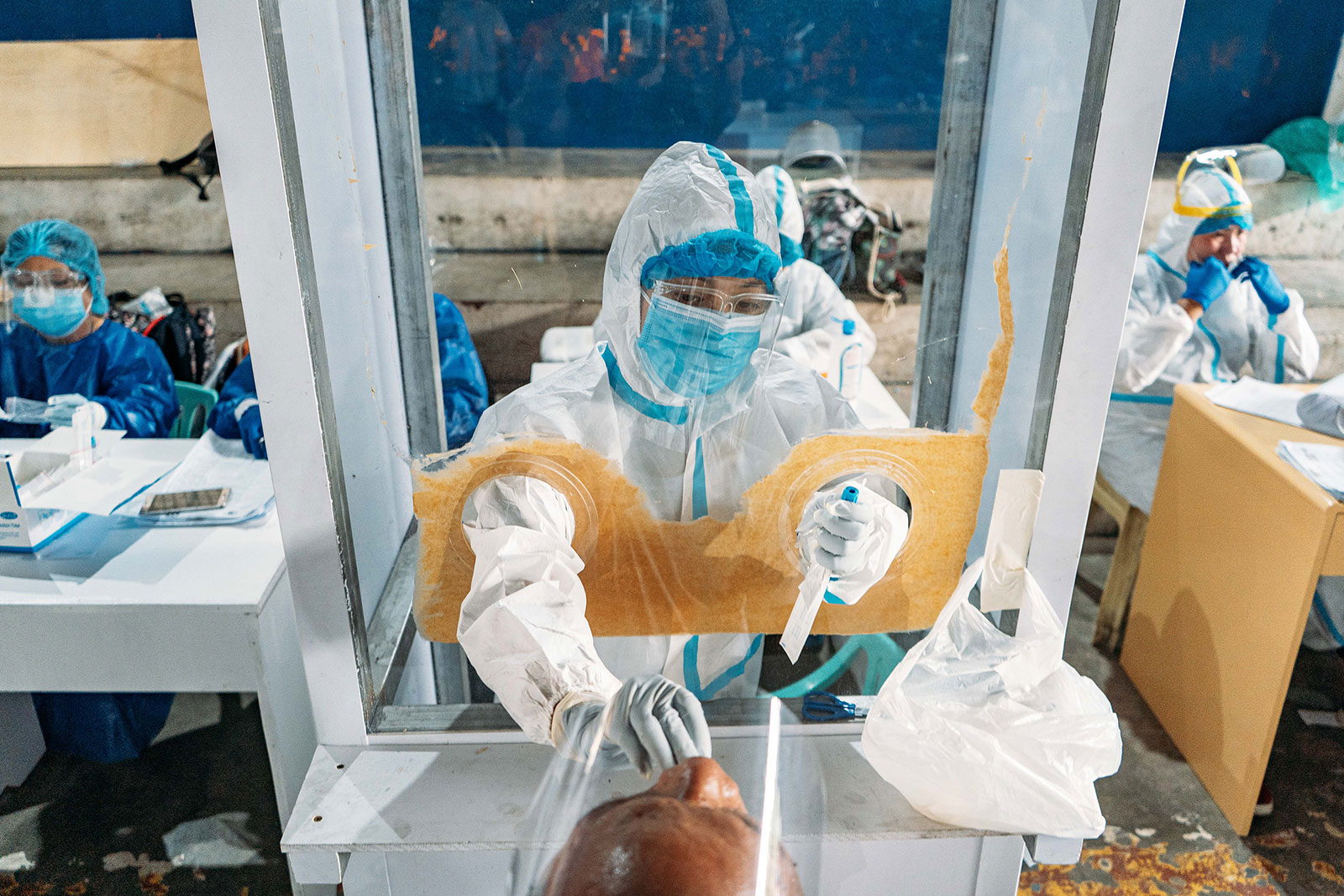 A health worker conducts a coronavirus test at a covered court in Metro Manila, Philippines, on October 6.
