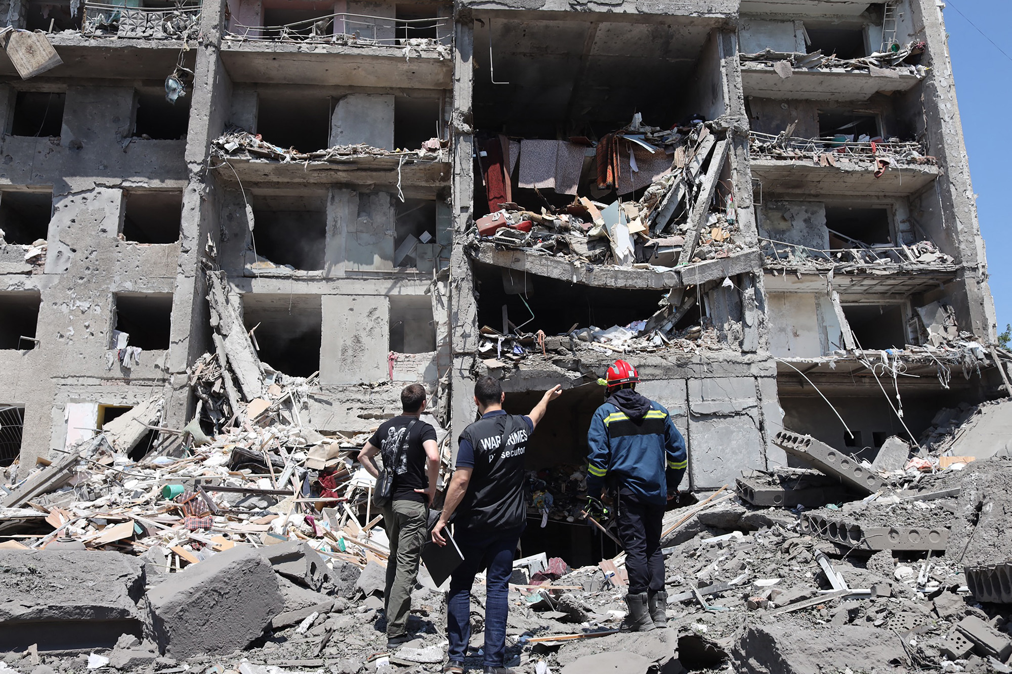 A war crimes prosecutor, center, looks at a destroyed building in the Ukrainian town of Sergiivka, near Odesa, Ukraine, on July 1.