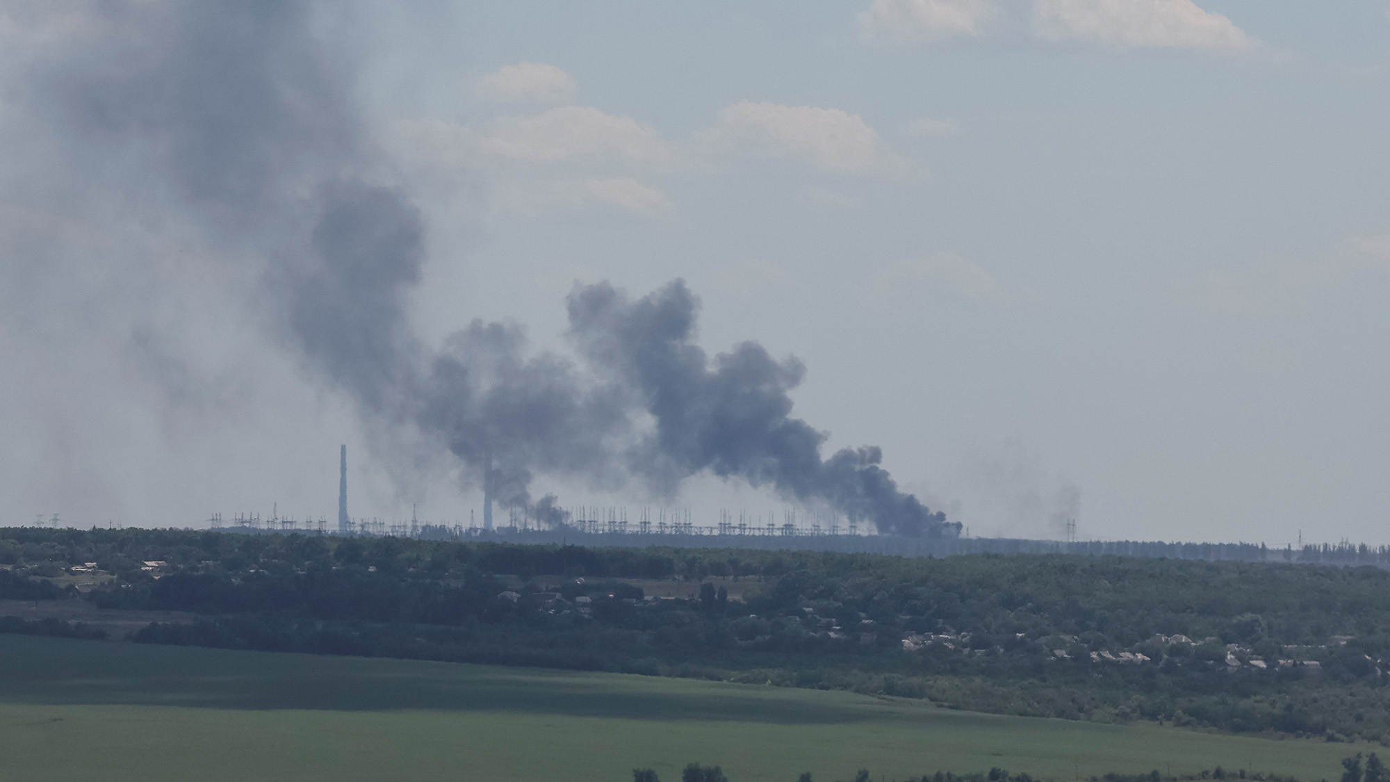 Vuhlehirsk's power plant burns in the distance after shelling in the Donetsk region on July 13.
