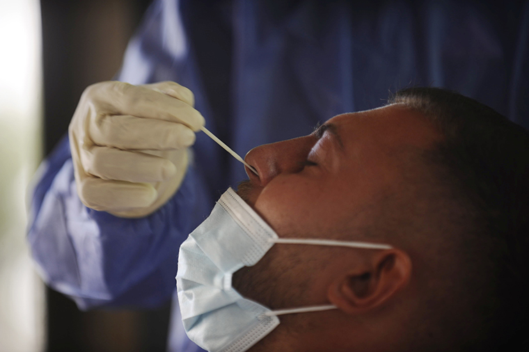 A man being tested for COVID-19 by a medical worker, south of Beirut, Lebanon on Oct. 4, 2020. 
