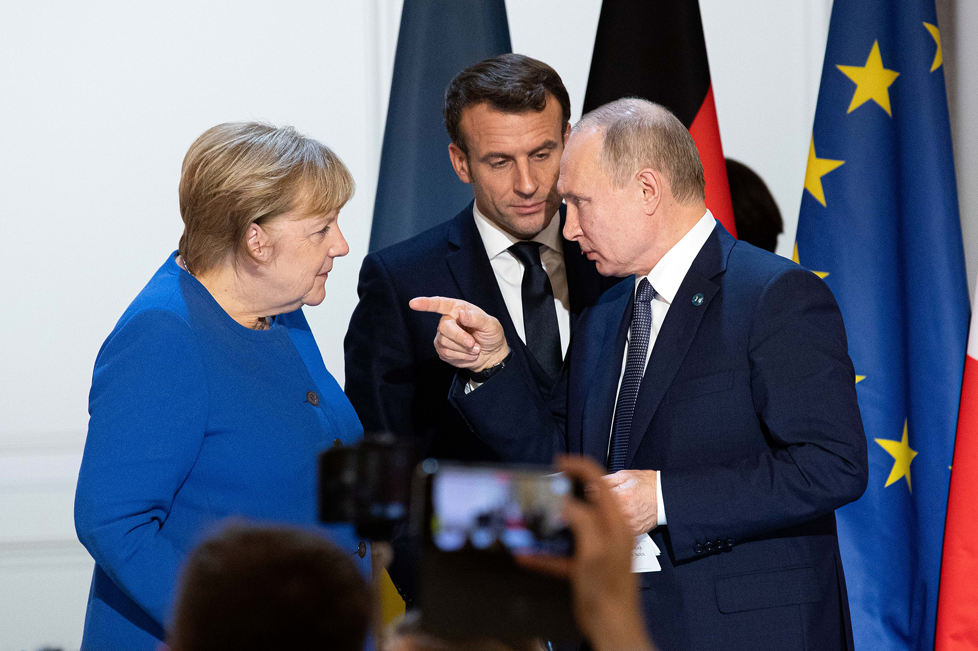 Vladimir Putin, Russia's president, right, gestures to Angela Merkel, Germany's chancellor, left, while Emmanuel Macron, France's president, looks on as they depart a news conference following a 4-way summit on Ukraine at Elysee Palace in Paris, France, on December 9, 2019.