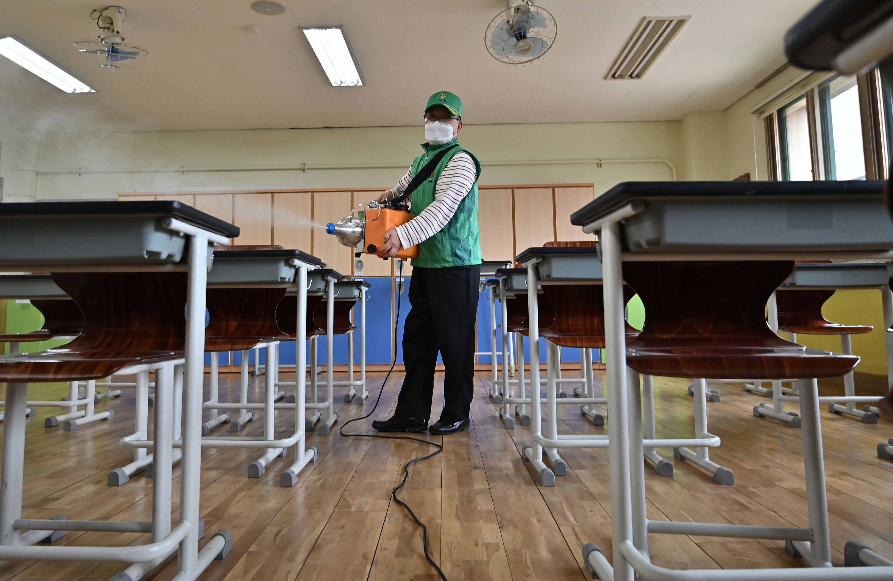 A worker disinfects a high school classroom in Seoul on May 19.