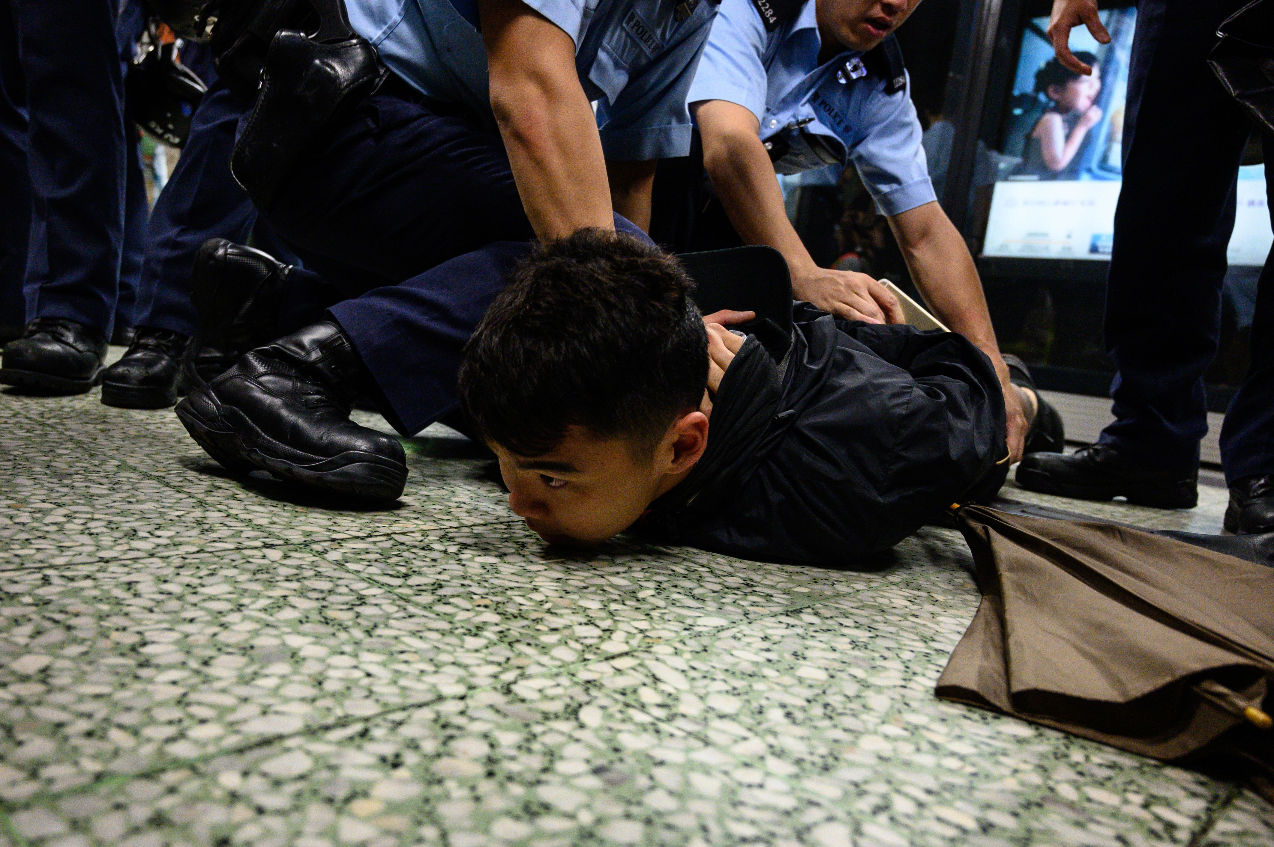 A man is arrested at the Lok Fu MTR station during a train disruption protest.