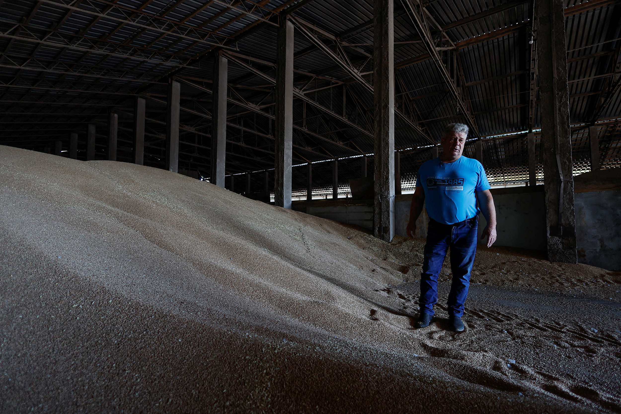 Ukrainian farmer Oleksandr Chubuk stands with wheat grain in the village of Zhurivka, Ukraine, on July 23.