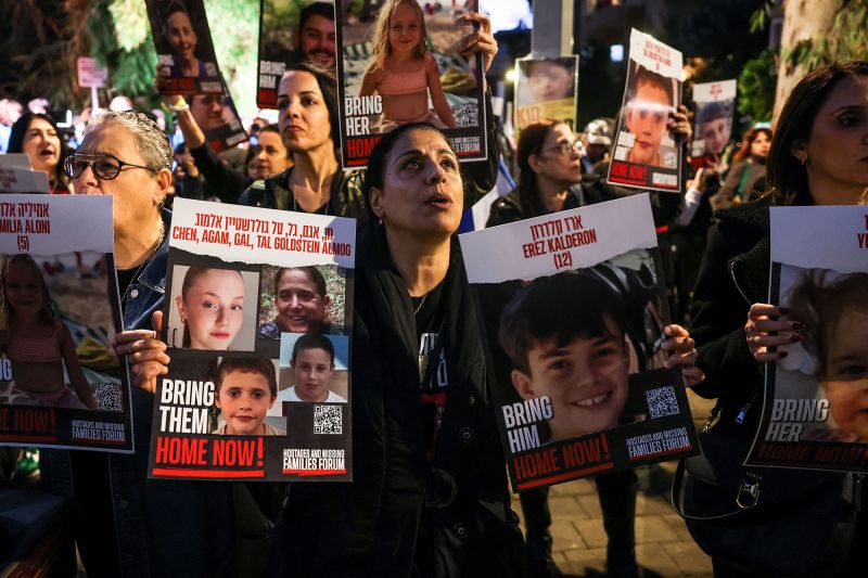 A woman holds portraits of hostages Erez Kalderon, 12, and of children of the Goldstein Almog family as protesters rally outside the UNICEF offices in Tel Aviv, Israel, on November 20.