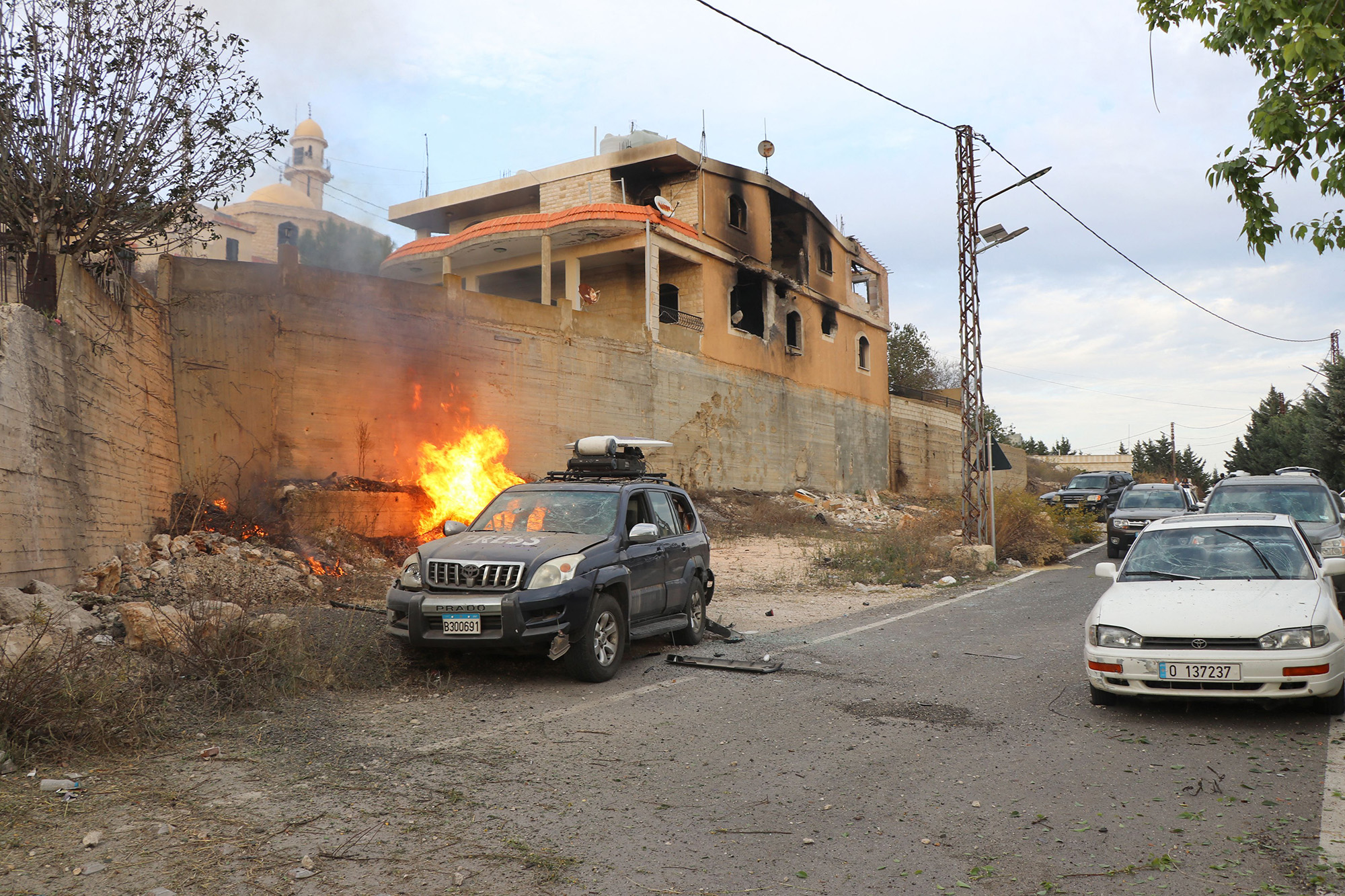 Flames erupt next to a press car following reported Israeli shelling in Lebanon's southern border village of Yaroun on November 13.