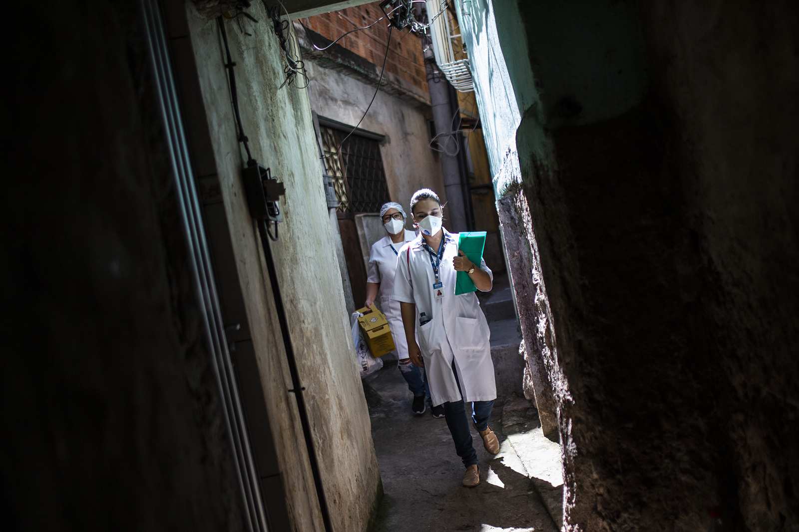 Health agents of the City of Rio de Janeiro walk in an alley of Favela da Mangueira on September 3.