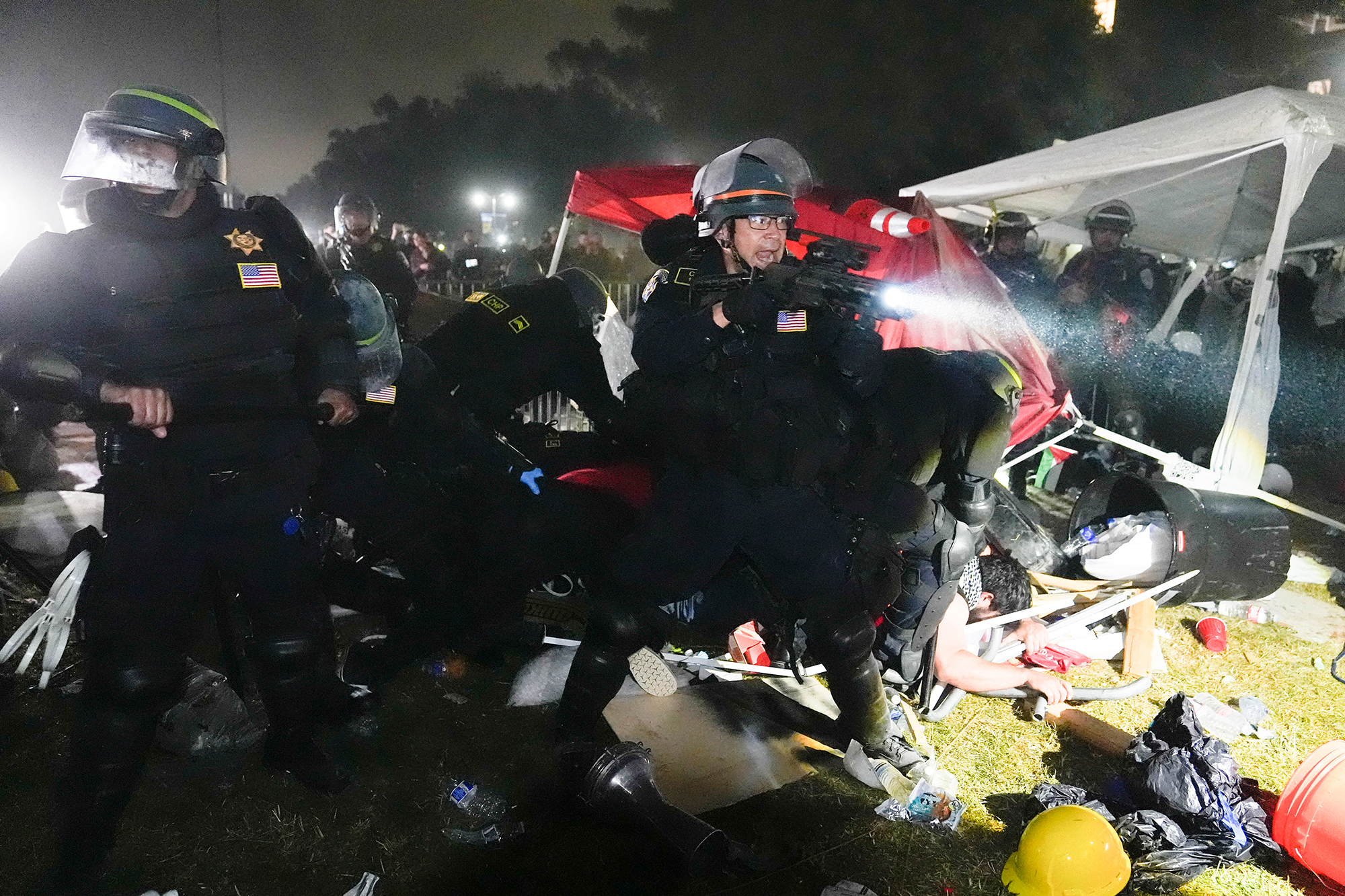 Police advance on protesters in the encampment. 