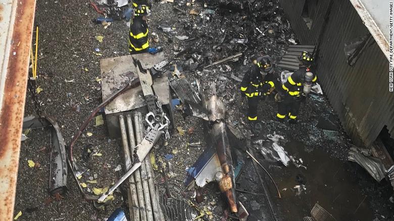 In this handout photo provided by the New York City Fire Department, firefighters work on the roof of 787 Seventh Ave. after a helicopter crashed there on June 10, 2019 in New York City.