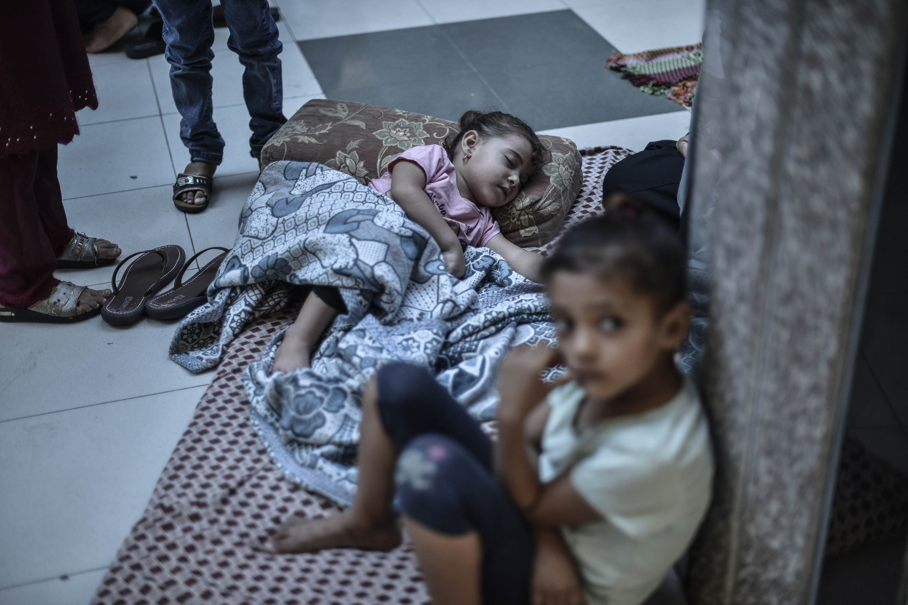Families take refuge in a hospital after homes were destroyed during Israeli airstrikes in Khan Younis, Gaza, on October 16. 