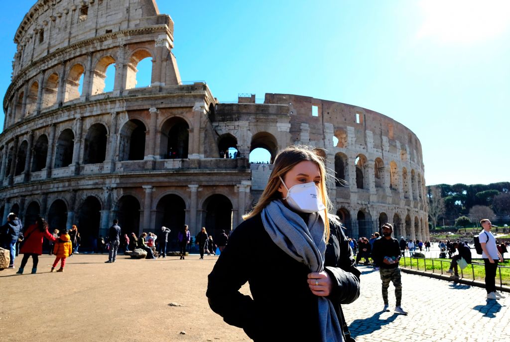 A tourist wears a protective respiratory mask outside the Colosseum in Rome on February 28, 2020.