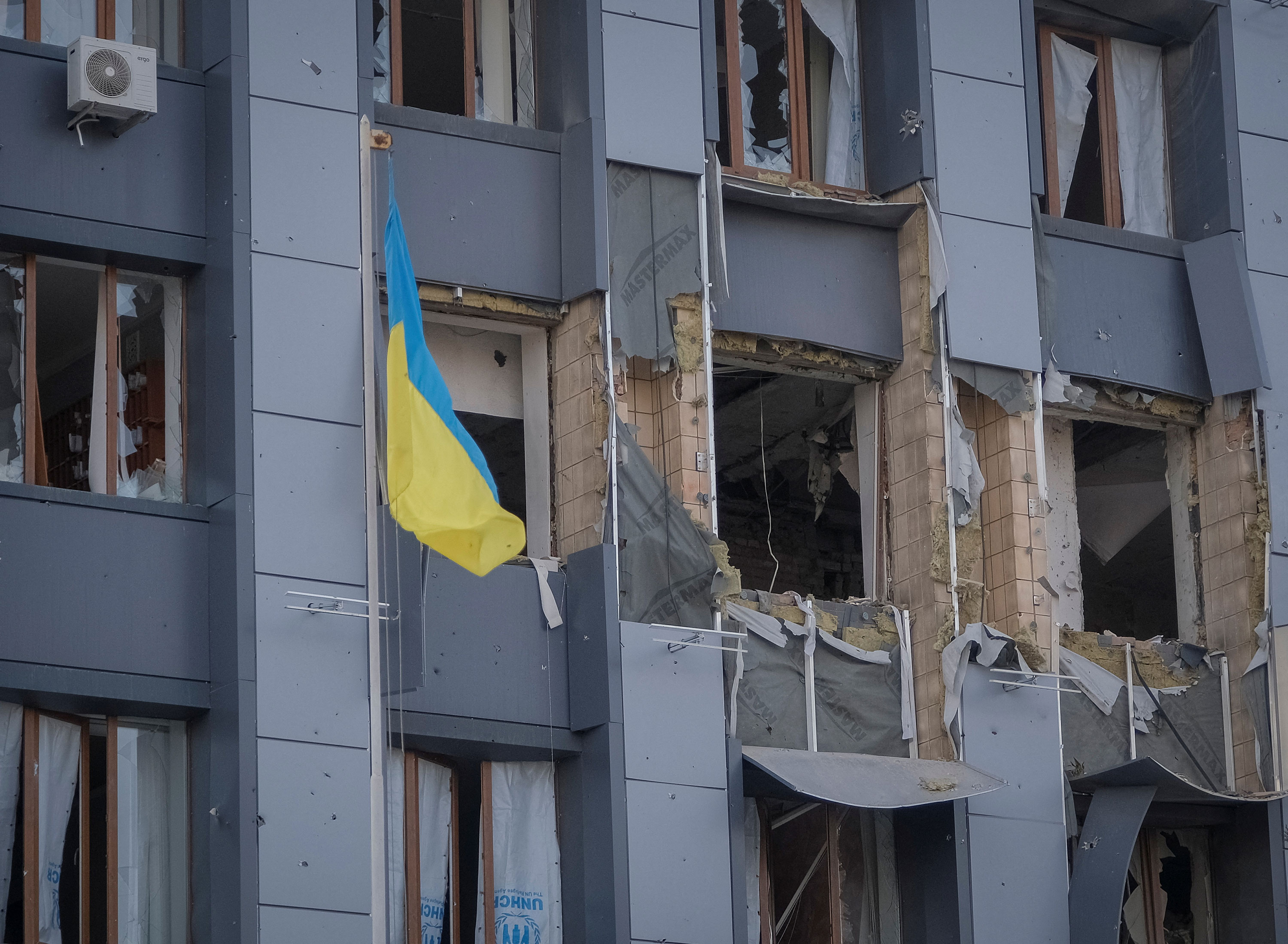 A Ukrainian flag is seen in front of a building damaged by a Russian military strike in Bakhmut on February 25. 