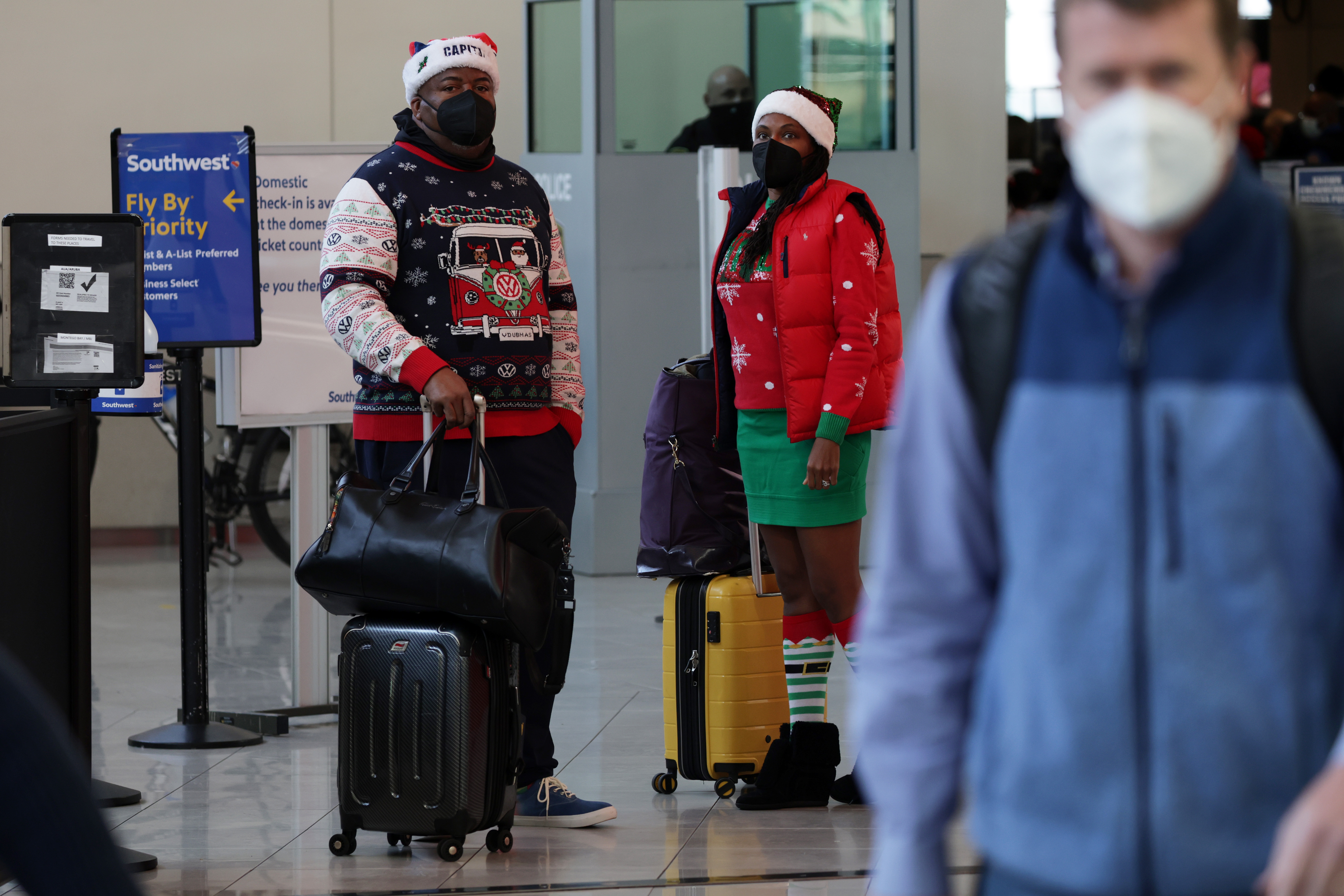 Passengers in Christmas outfits are seen in a terminal at Baltimore/Washington International Thurgood Marshall Airport (BWI) on December 22, 2021 in Baltimore, Maryland. AAA predicted more than 109 million Americans will travel 50 miles or more over Christmas and New Year holidays, a spike of 27.7% over last year. 