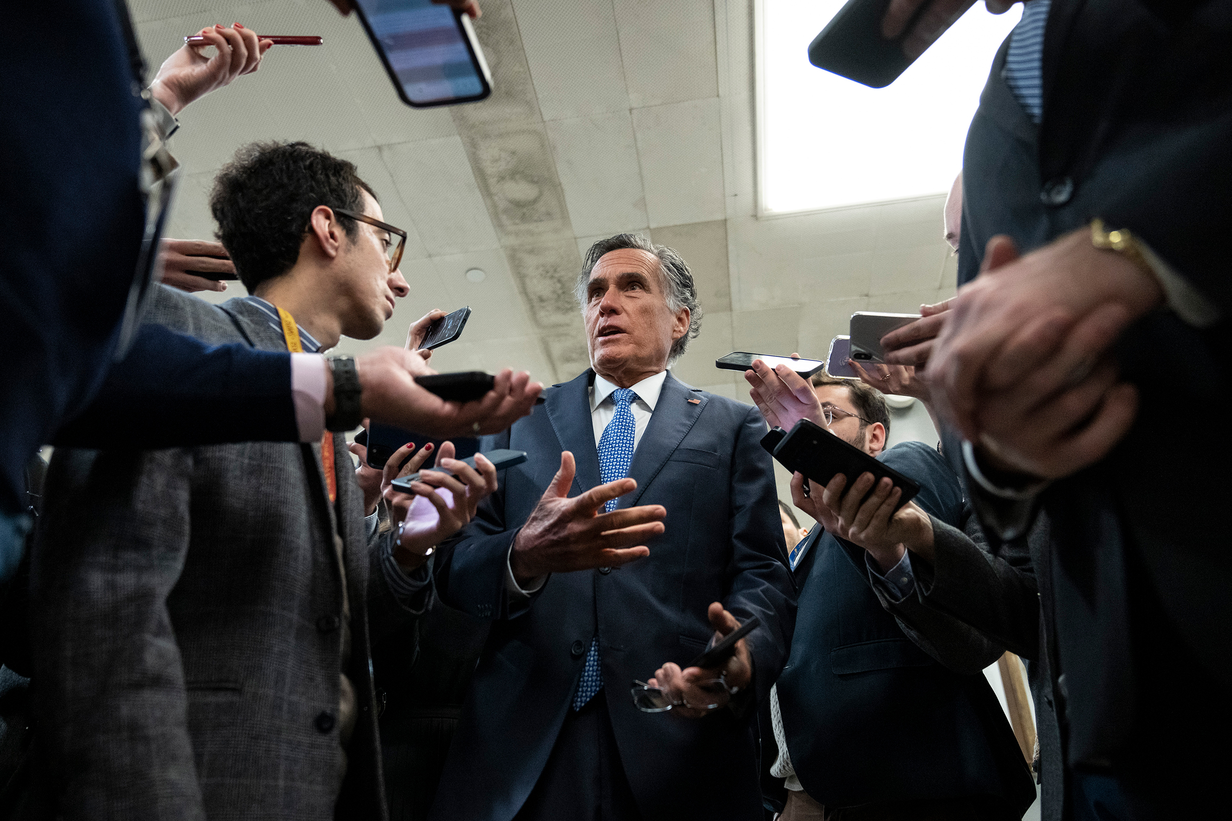Sen. Mitt Romney speaks to reporters in the Senate subway on his way to a vote at the Capitol on March 14, in Washington, DC. 