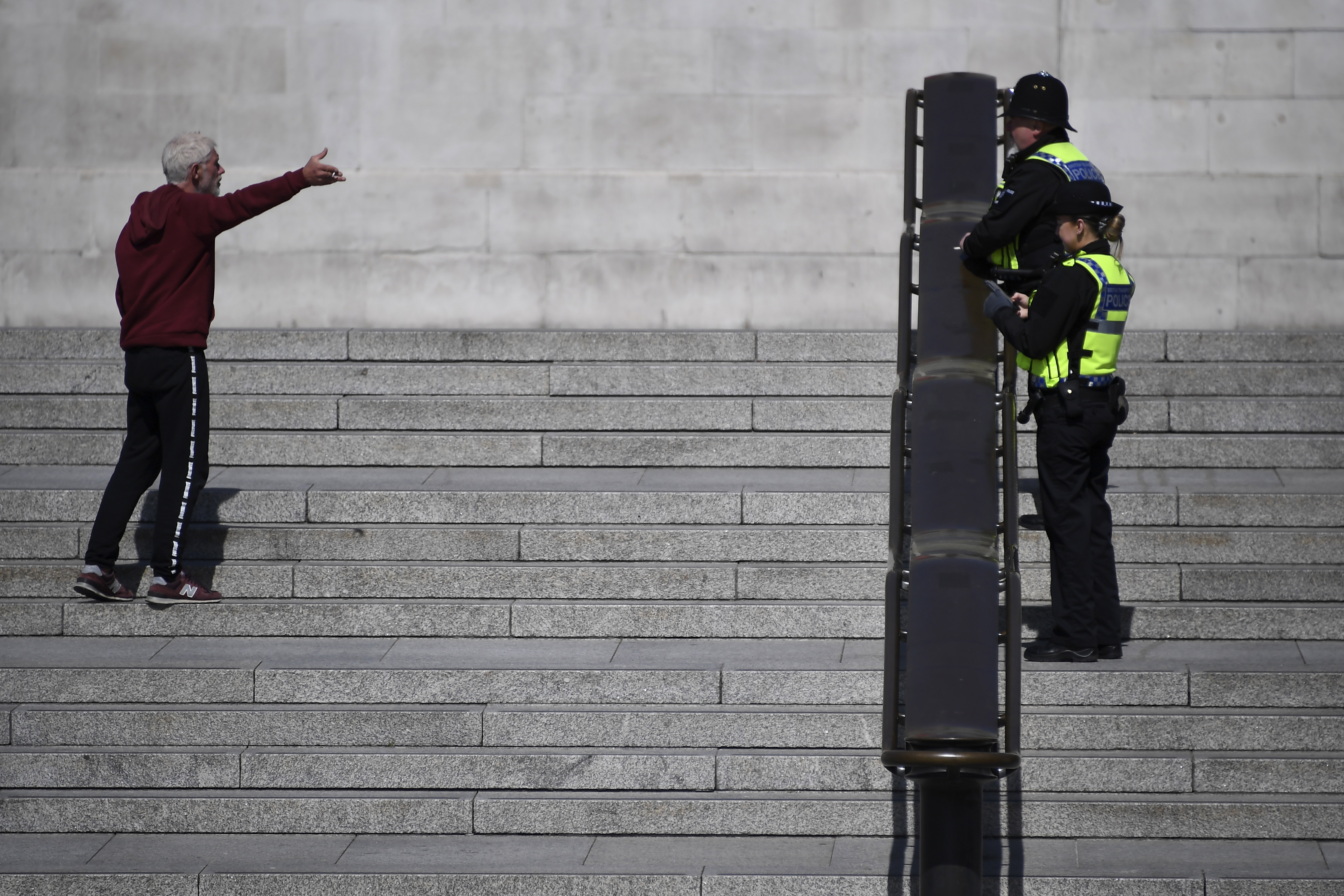 Police officers talk to a man in Trafalgar Square in London on April 14.