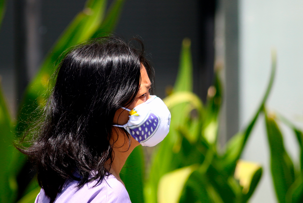 A woman wears a mask as a precaution against the coronavirus in Honolulu on Tuesday, April 7.