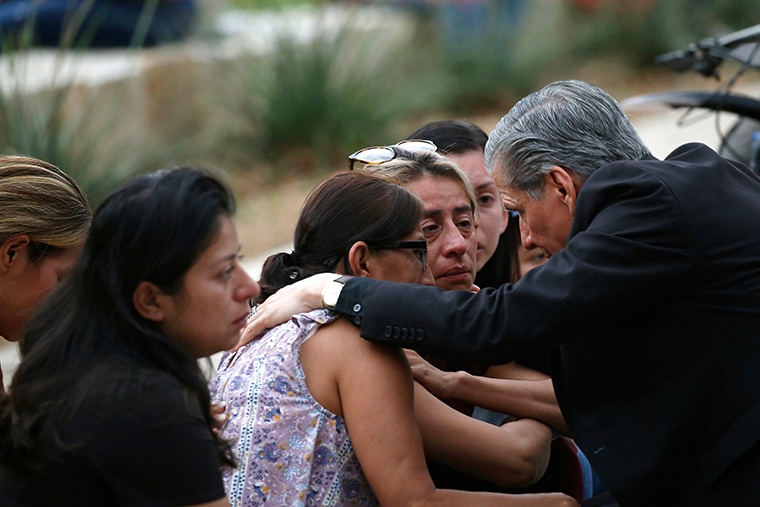 The Archbishop of San Antonio, Gustavo Garcia Seller, comforts families outside of the Civic Center in Uvalde, Texas on Tuesday, May 24.